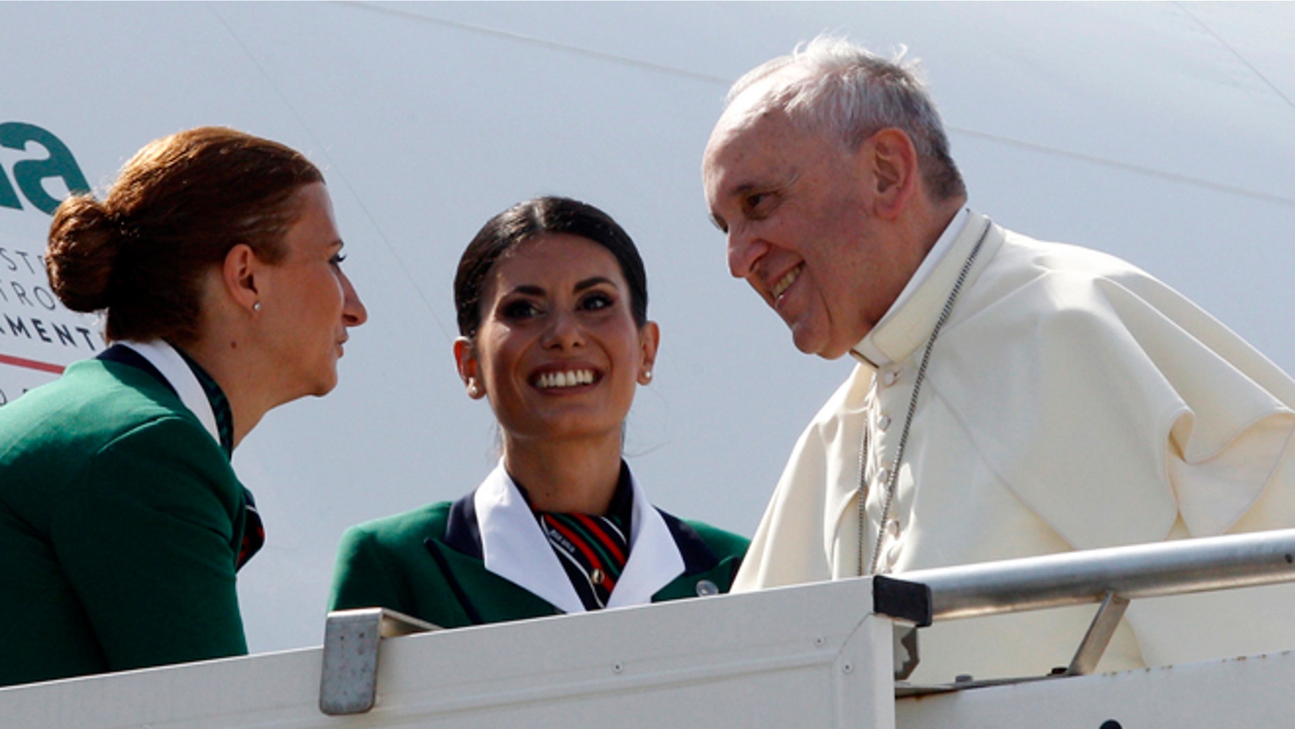 Aug 13, 2014: Pope Francis is welcomed by two hostesses as he boards a plane to South Korea, at Rome's Fiumicino international airport. (AP)