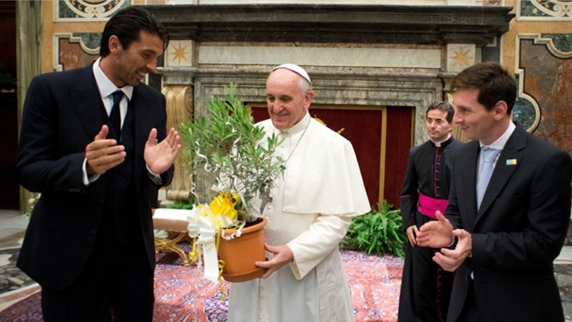 Aug. 13, 2013: In this photo provided by the Vatican newspaper L'Osservatore Romano, Pope Francis is applauded by Italy goalie Gianluigi Buffon, left, and Argentine soccer star Lionel Messi during a private audience at the Vatican.