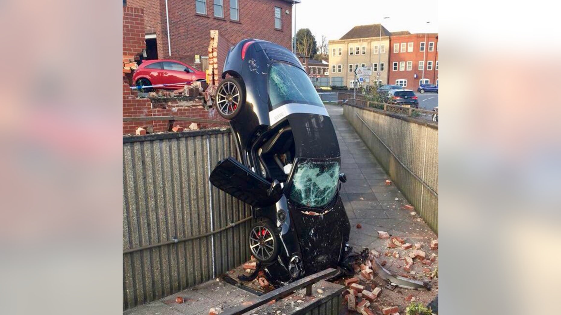 The catastrophic result of a 73 year old's Porsche colliding with a call and crashing into a pedestrian subway. See Masons story MNPORSCHE; The incident happened just after 6pm on Thursday evening (5 Apr). it is believed that the car was parked in a car park before it crashed through the wall. Several police cars and two fire engines were sent to the scene.