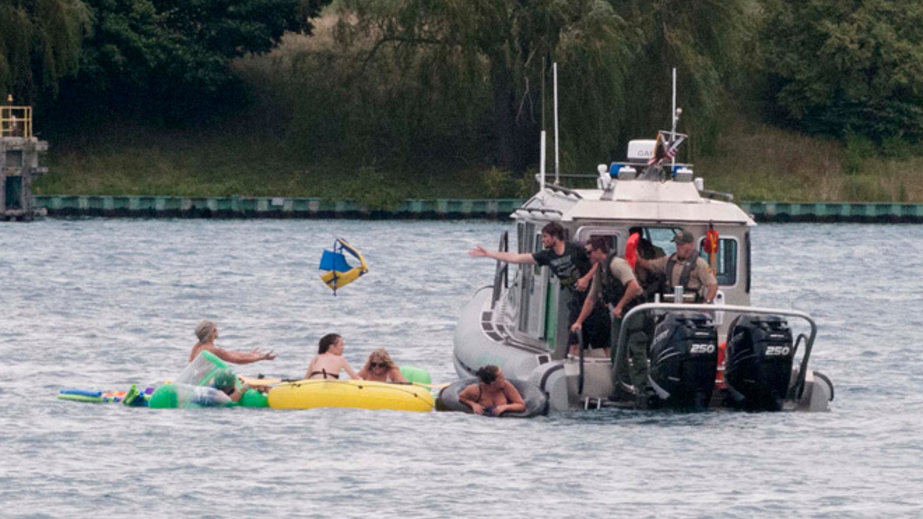 A Customs and Border Protection boat helps floaters during Float Down on the St. Clair River in Port Huron, Mich., Sunday, Aug. 21, 2016. The west winds blew most boaters toward the Canada shore and they had to be pulled back to the U.S.