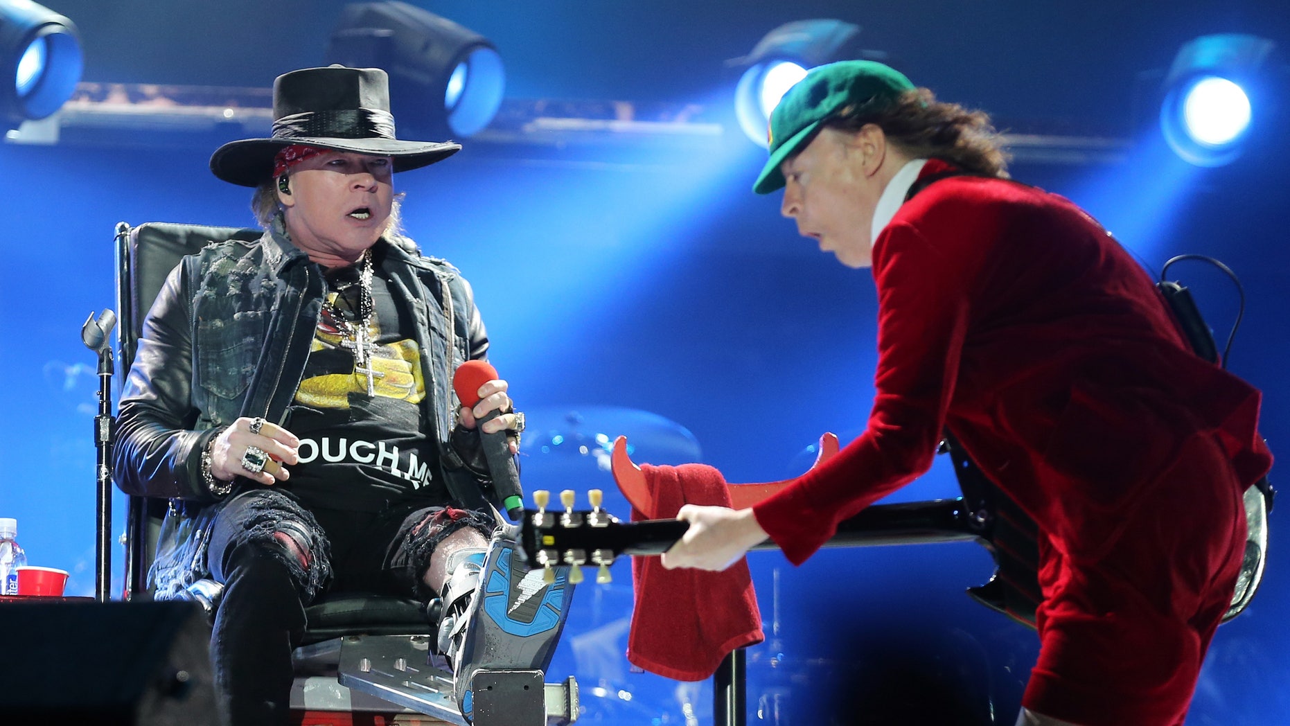 Guns N' Roses singer Axl Rose, left, watches AC/DC lead guitar player Angus Young perform during the concert of Australian rock band AC/DC in Lisbon Saturday night, May 7, 2016.