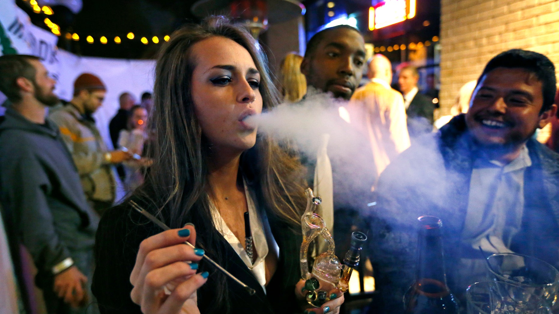 Partygoers smoke marijuana during a Prohibition-themed event at a bar in Denver.
