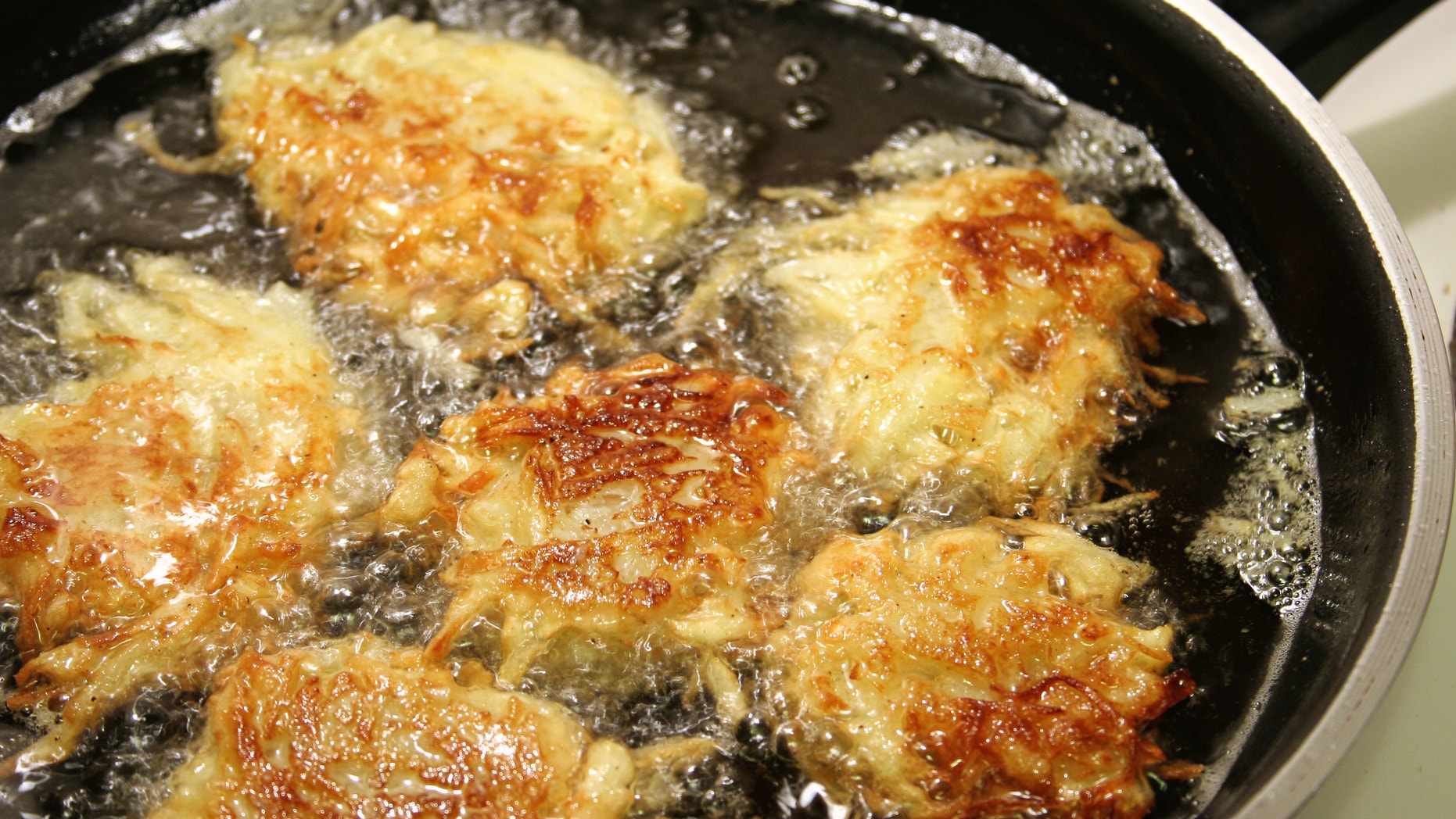 Potato latkes for Hanukah frying in oil.
