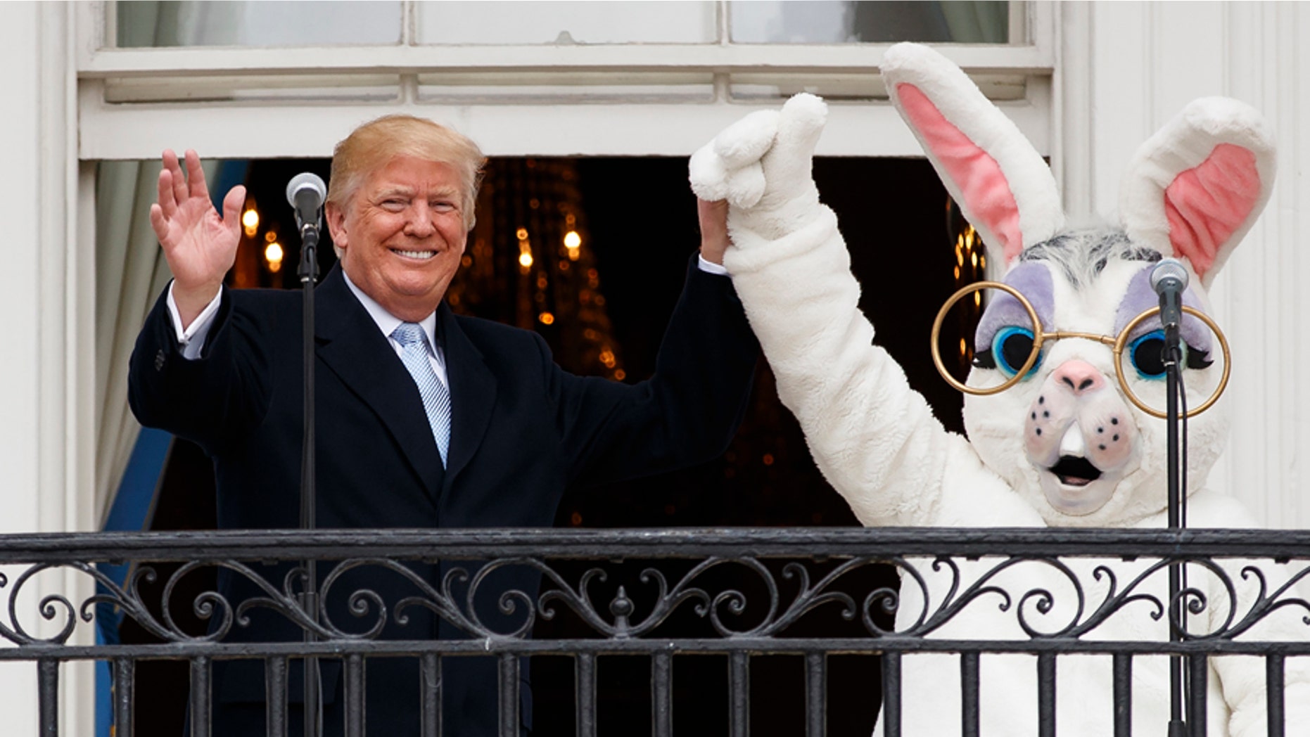 President Donald Trump holds hands with the Easter Bunny on the Truman Balcony of the White House in Washington, Monday, April 2, 2018, during the annual White House Easter Egg Roll. (AP Photo/Carolyn Kaster)
