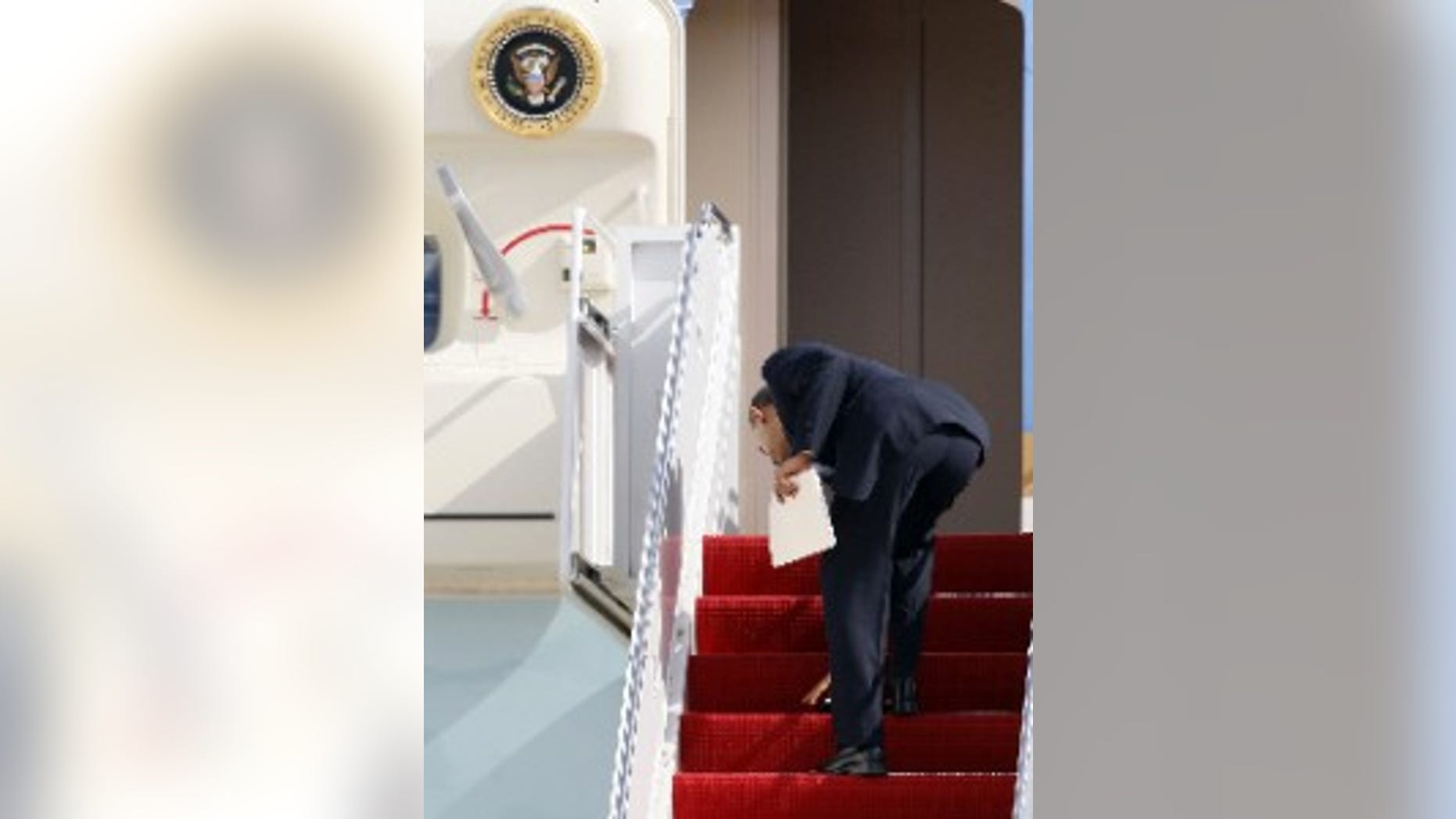 President Obama leans down to pick up his blackberry on the steps of Air Force One (AP Photo)