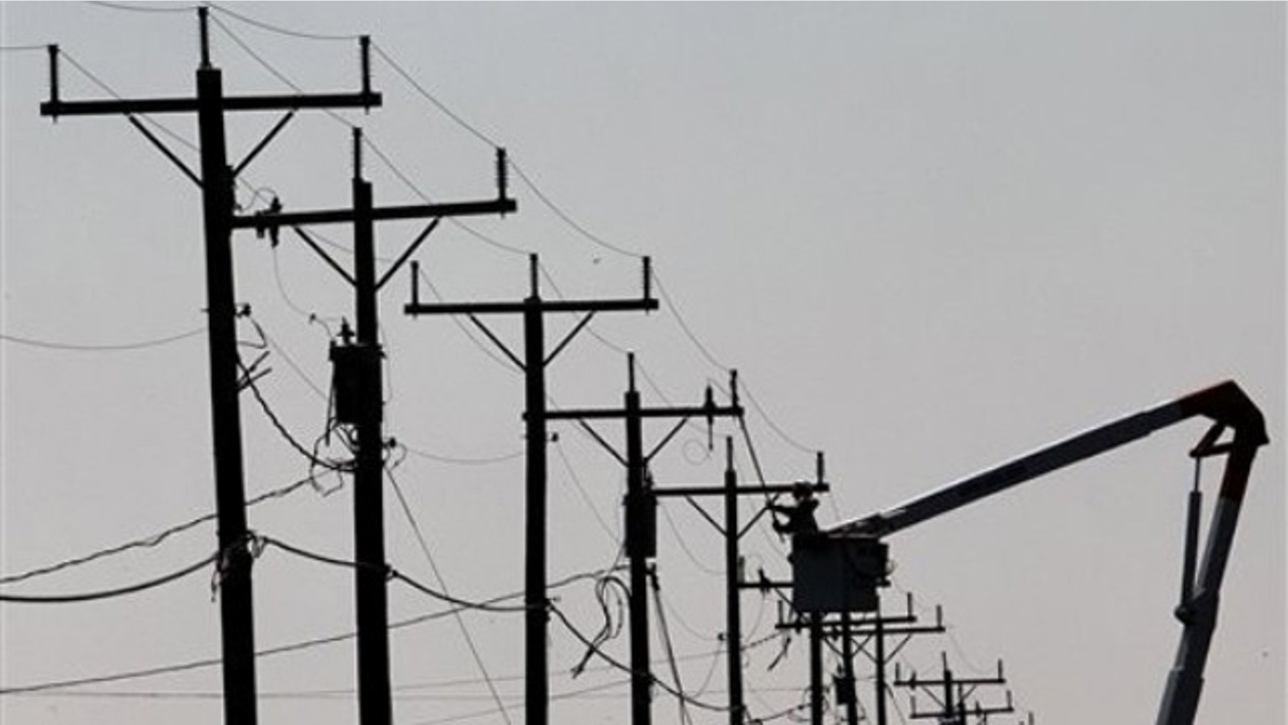 In this Aug. 28 file photo, a utility worker makes repairs on power lines in Nags Head, N.C.