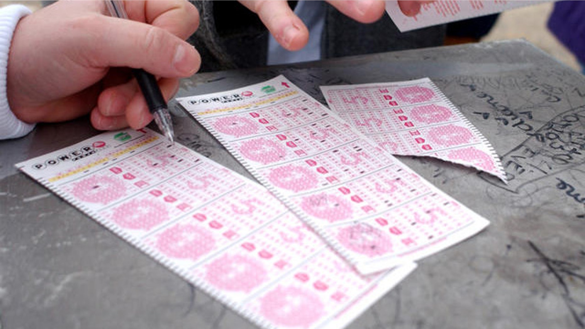Customers are shown here picking numbers on Powerball lottery forms.