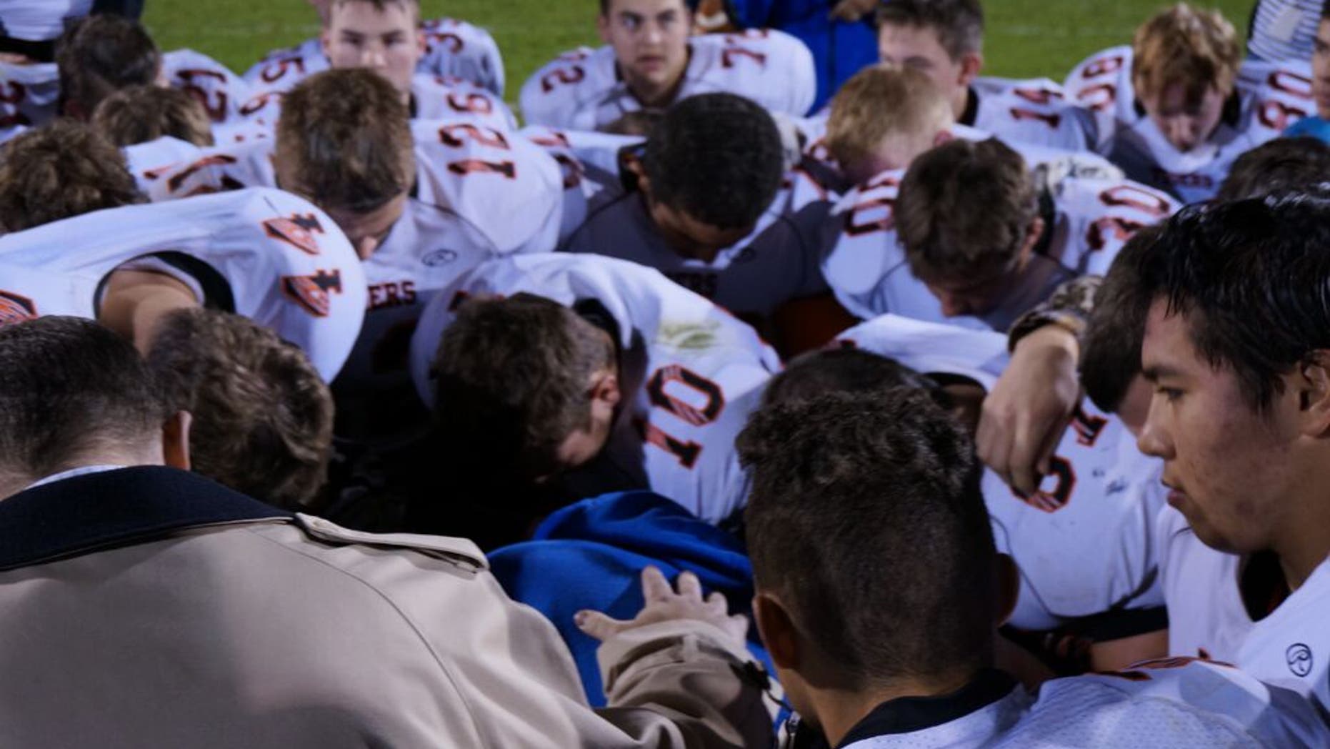 October 16: Coach Kennedy prays on the field after the high school's homecoming game. (Courtesy Liberty Institute)