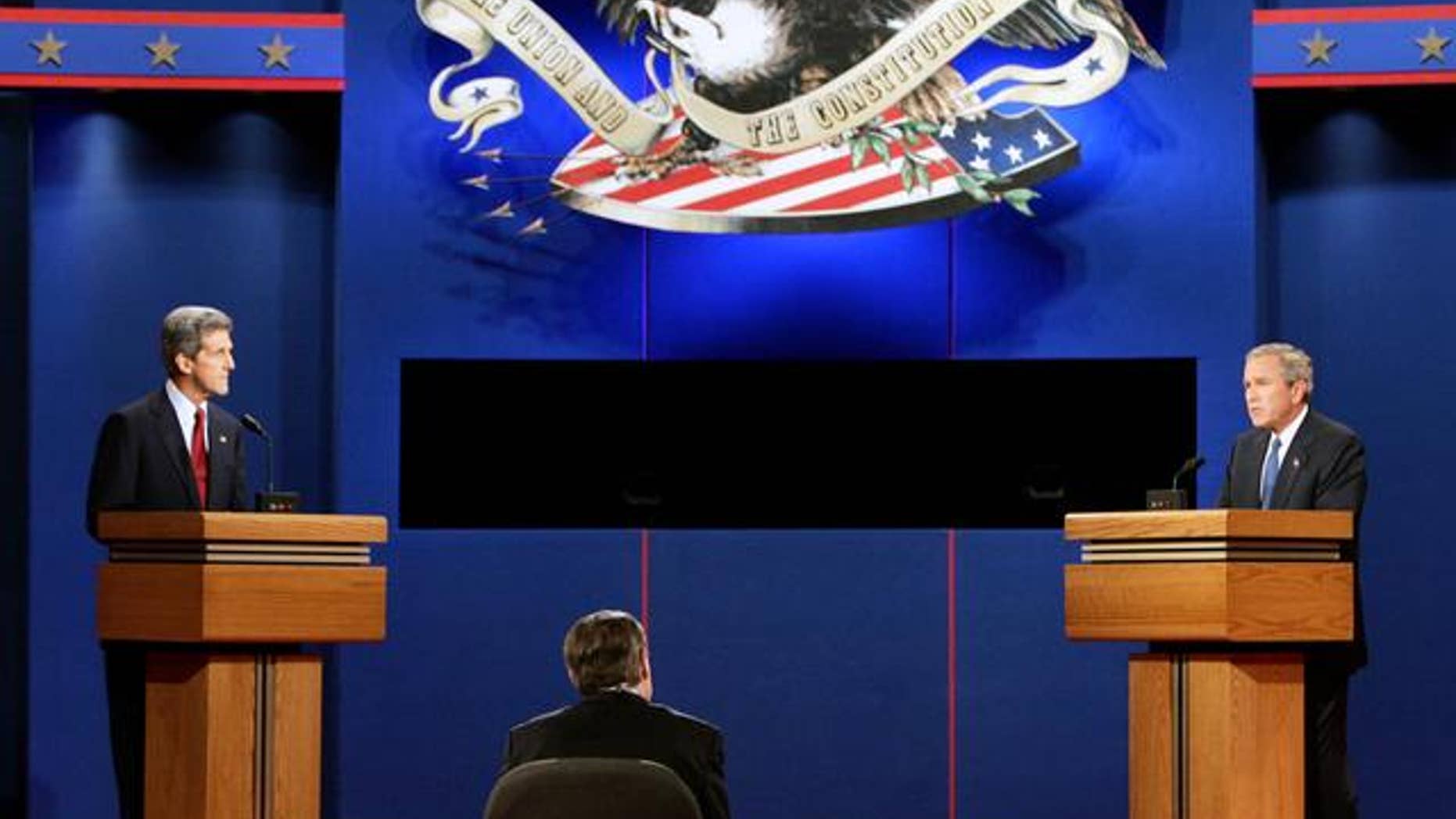 Democratic presidential candidate John Kerry, left, listens to President Bush during the presidential debate in Coral Gables, Fla., Thursday, Sept. 30 2004. Debate moderator Jim Lehrer is at center. (AP Photo/Ron Edmonds)