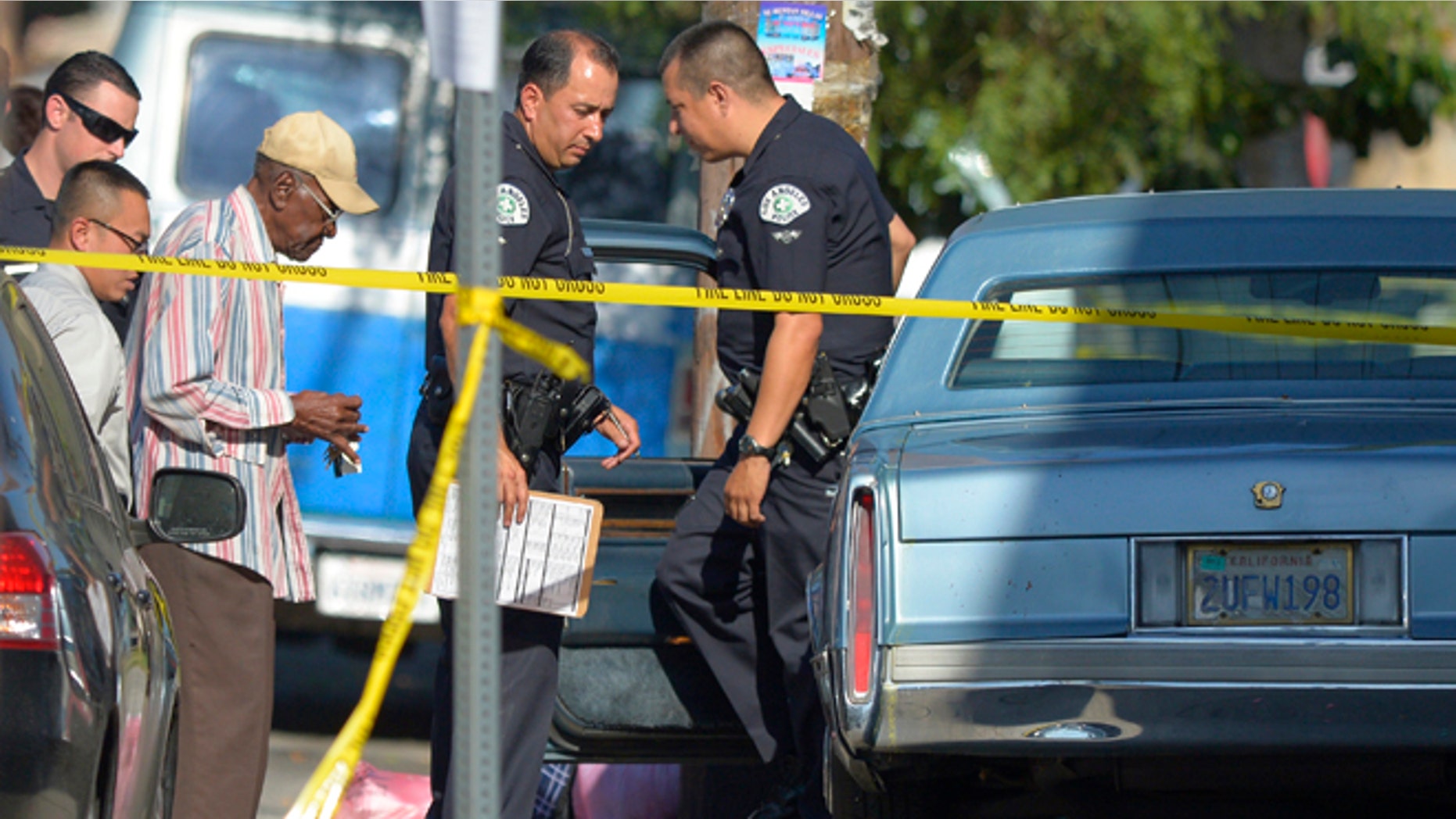 August 29, 2012: Preston Carter, left, 100, talks with police officers after police say his car went onto a sidewalk and plowed into a group of parents and children outside a South Los Angeles elementary school in Los Angeles. Nine children and two adults were injured in the wreck.