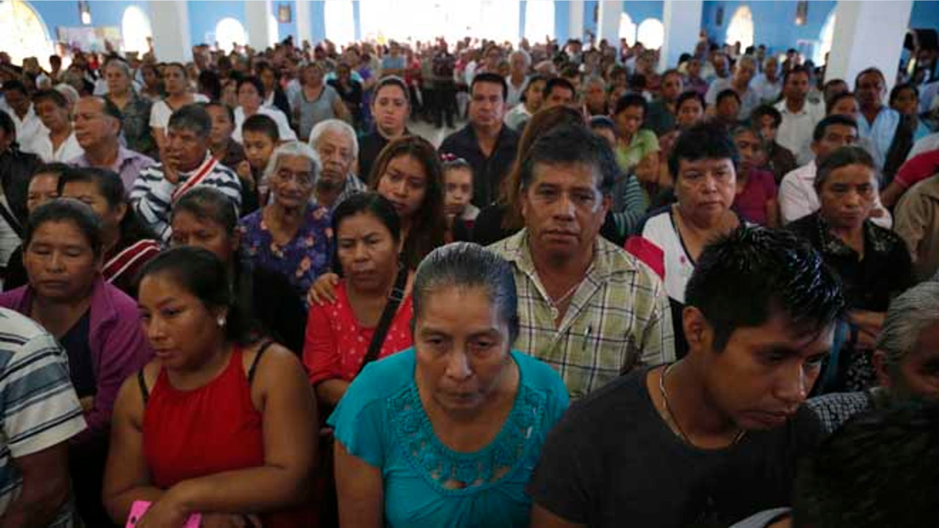 This Sept. 21, 2016 photo shows a packed Our Lady of Asuncion Church for the funeral Mass of slain Rev. Jose Alfredo Suarez de la Cruz, who was found bound and shot to death alongside another priest, in Paso Blanco, Veracruz state, Mexico, his hometown. The killings in the troubled Gulf state of Veracruz came at a moment of heightened tension between the Roman Catholic Church and Mexicoââ¬â¢s government. (AP Photo/Marco Ugarte)