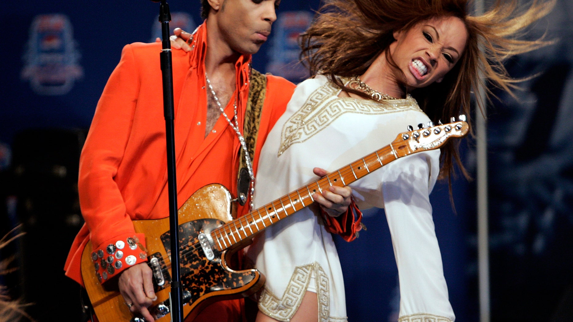 Musician Prince (L) performs for members of the news media in Miami Beach, Florida February 1, 2007. Prince will be the halftime entertainment at Super Bowl XLI to be played February 4. REUTERS/Brian Snyder (UNITED STATES) - RTR1LVTF