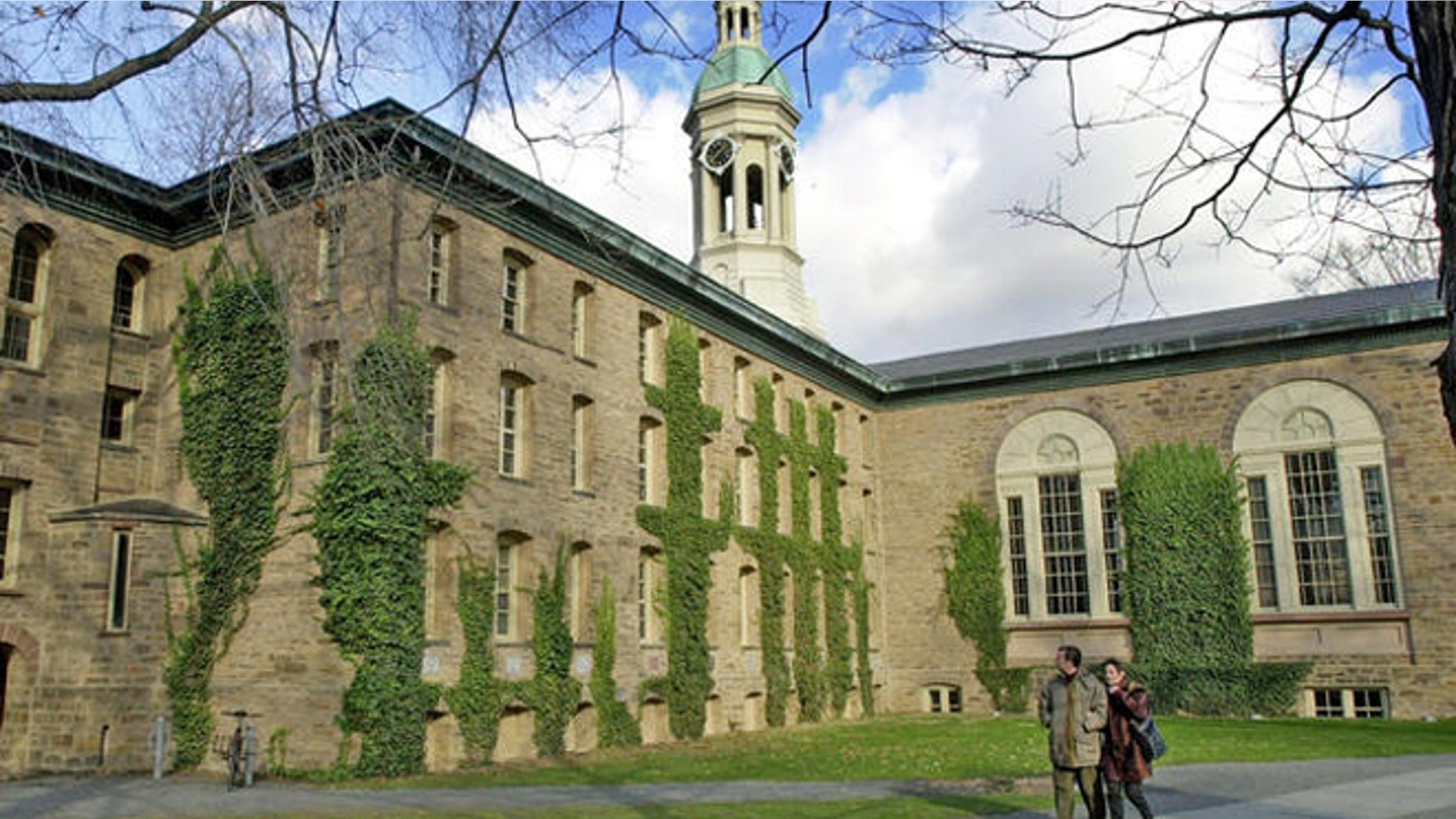 A couple walks past Nassau Hall on the Princeton University campus in Princeton, N.J.