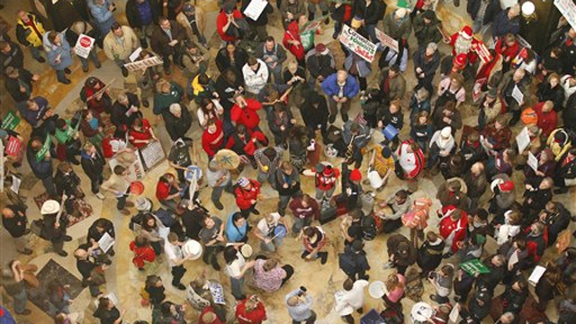 Protesters bang drums and chant inside the state Capitol Feb. 22 in Madison, Wis.