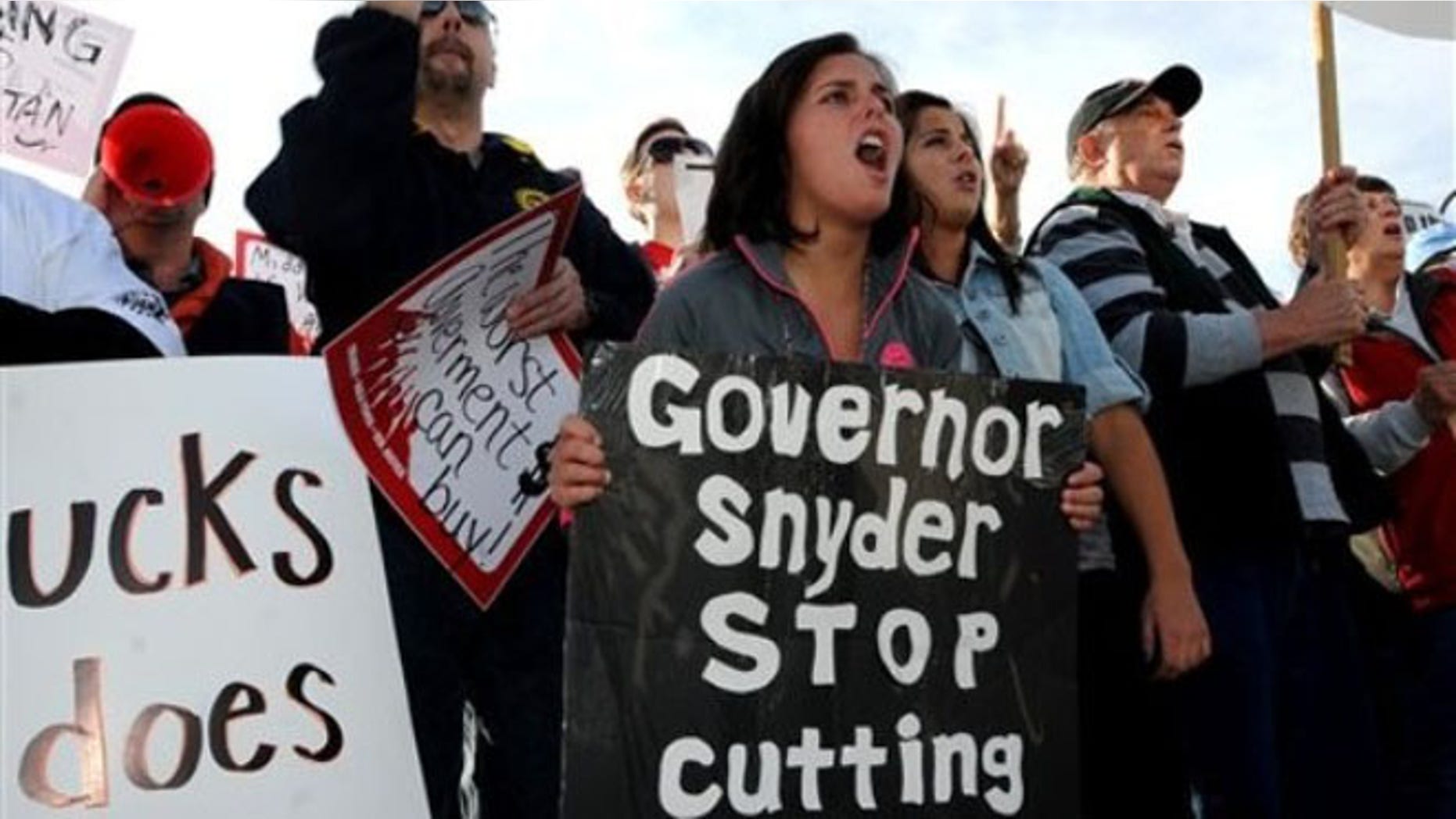 FILE: April 17, 2012: Protesters demonstrate against Michigan Gov. Rick Snyder and Wisconsin Gov. Scott Walker outside the annual Reagan Dinner in Troy, Mich.