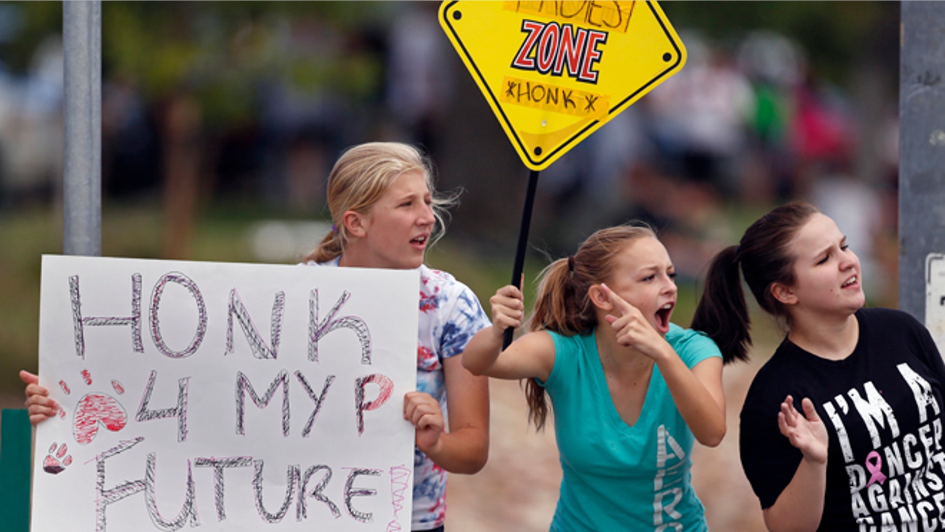 Sept. 23, 2014: Protesting Pamona High School students, left to right, Ciana Vrtikapa, Tori Suyak, and Becca Ferris engage with passing motorists in a busy intersection near their school, during a multi-school protest against a Jefferson County School Board proposal to emphasize patriotism and downplay civil unrest in the teaching of U.S. history, in Arvada, Colo. (AP)