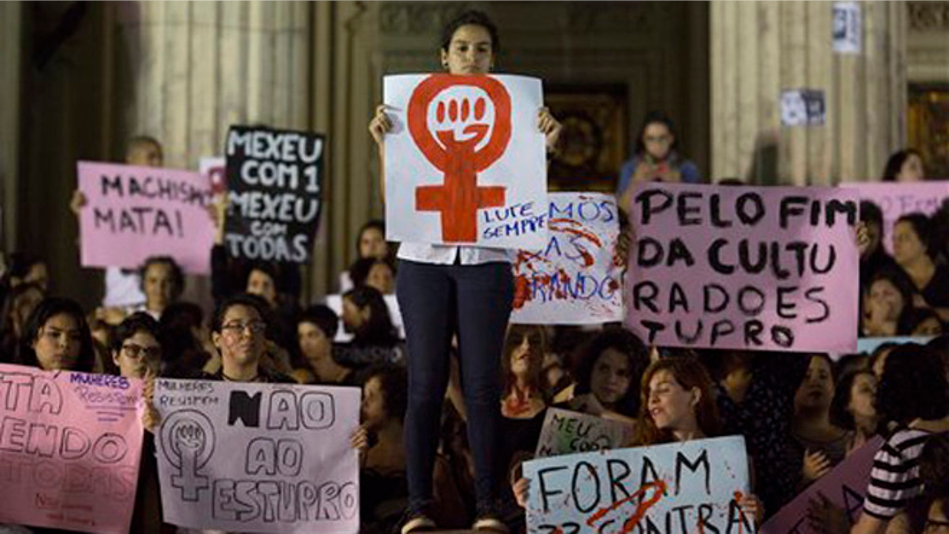 Demonstrators protest the gang rape of a 16-year-old girl in Rio de Janeiro, Brazil, Friday, May 27, 2016. The assault last Saturday came to light after several men joked about the attack online, posting graphic photos and videos of the unconscious, naked teen on Twitter. The signs read in Portuguese "Always fight," center, "No to rape," center left, and "It was 33 against all (women)," bottom right, and "For the end of rape culture," center right. (AP Photo/Leo Correa)