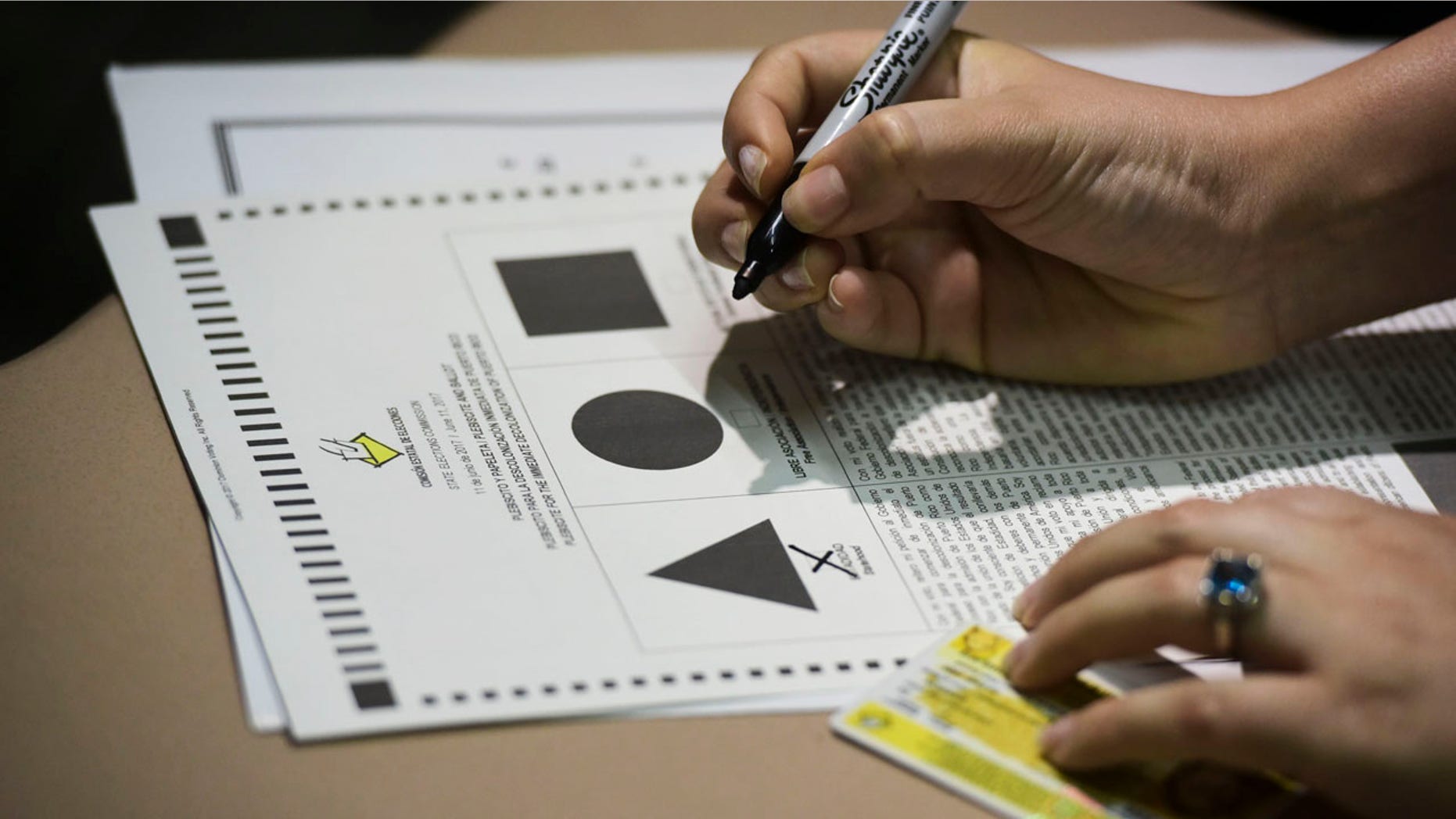 A Puerto Rican citizen votes during the fifth referendum in San Juan, Puerto Rico, Sunday, June 11, 2017. Residents of the U.S. Territory had to choose between the options of statehood, free association/independence and current territorial status. (AP Photo/Carlos Giusti)