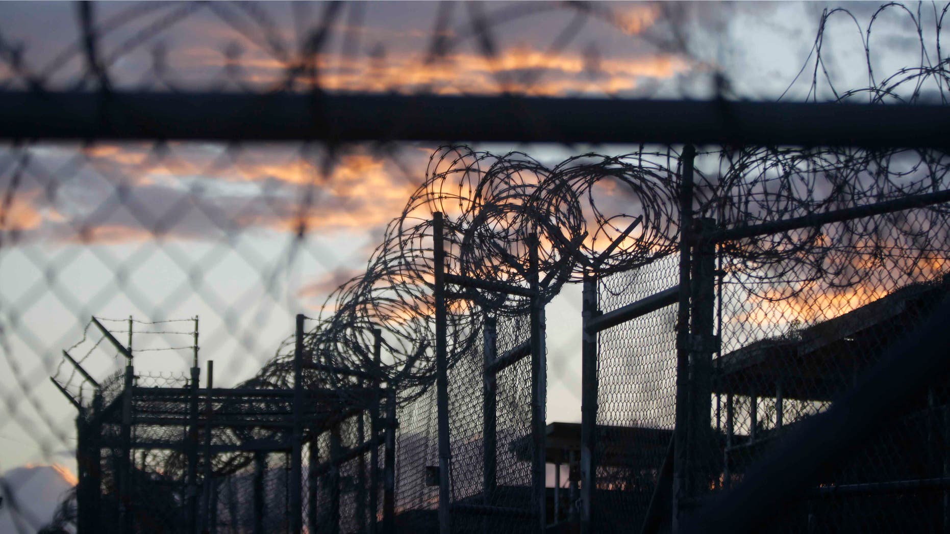 FILE - In this Nov. 21, 2013 file photo reviewed by the U.S. military, dawn arrives at the now closed Camp X-Ray, which was used as the first detention facility for suspected militants captured after the Sept. 11 attacks, at the Guantanamo Bay Naval Base in Cuba. A government board reviewing the cases of dozens of men held at Guantanamo has decided that detainee Abdul Rahman Shalabi can return to his native Saudi Arabia, according to a brief statement by the board on Friday, June 26, 2015. Shalabi has been on a nine-year hunger strike to protest his indefinite confinement without charge. (AP Photo/Charles Dharapak, File)