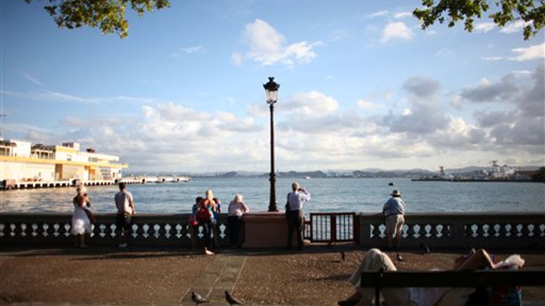 FILE - In this Nov. 23, 2011 file photo, tourists look out from the pier near the cruise ship terminal in Old San Juan, Puerto Rico. The Caribbean country is launching a two-day summit starting Thursday, April 24, 2014 to lure wealthy investors to the U.S. territory as it struggles to emerge from a nearly eight-year recession. (AP Photo/Ricardo Arduengo, File)