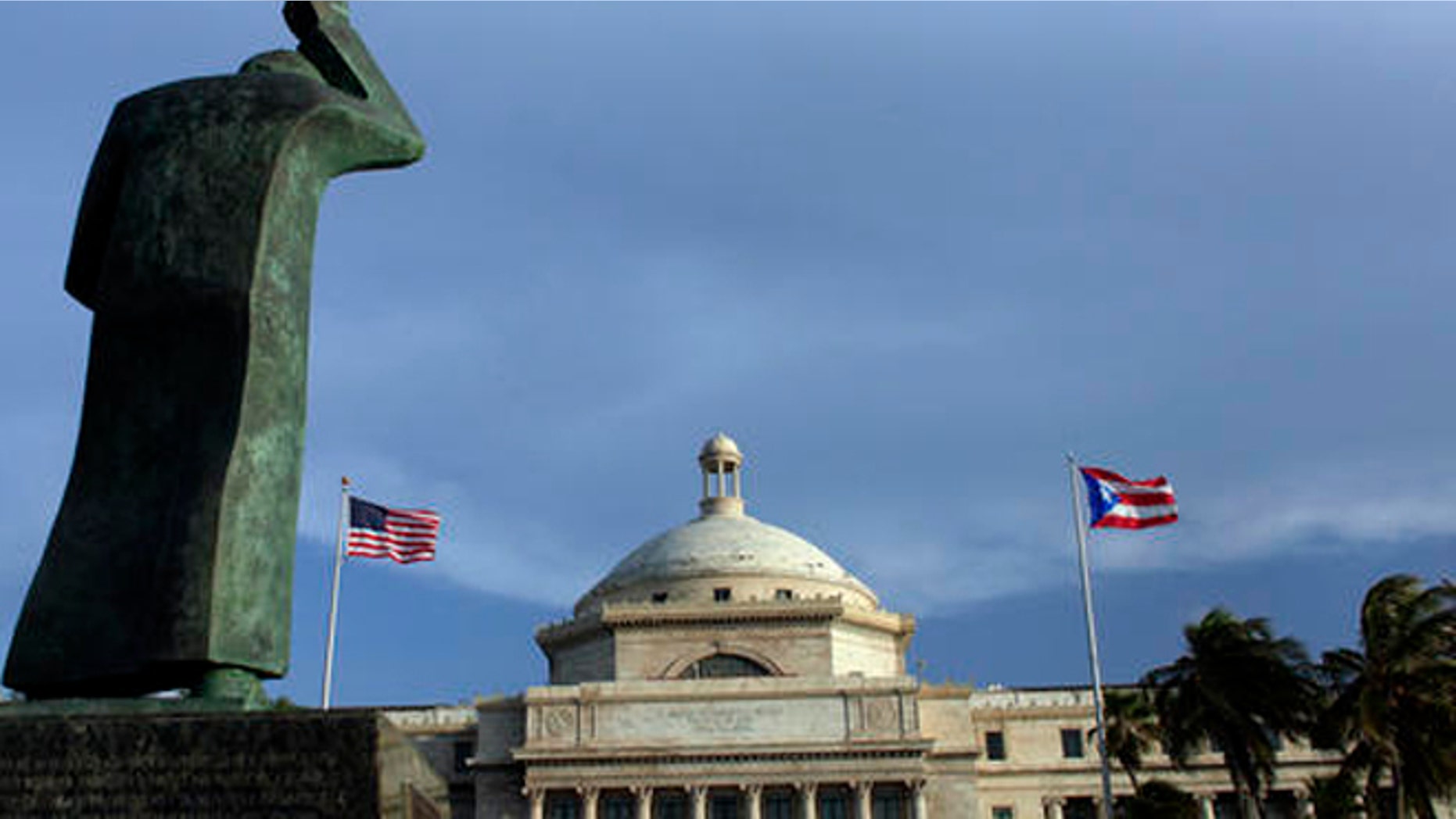 A bronze statue of San Juan Bautista stands in front of Puerto Ricos capitol in San Juan.