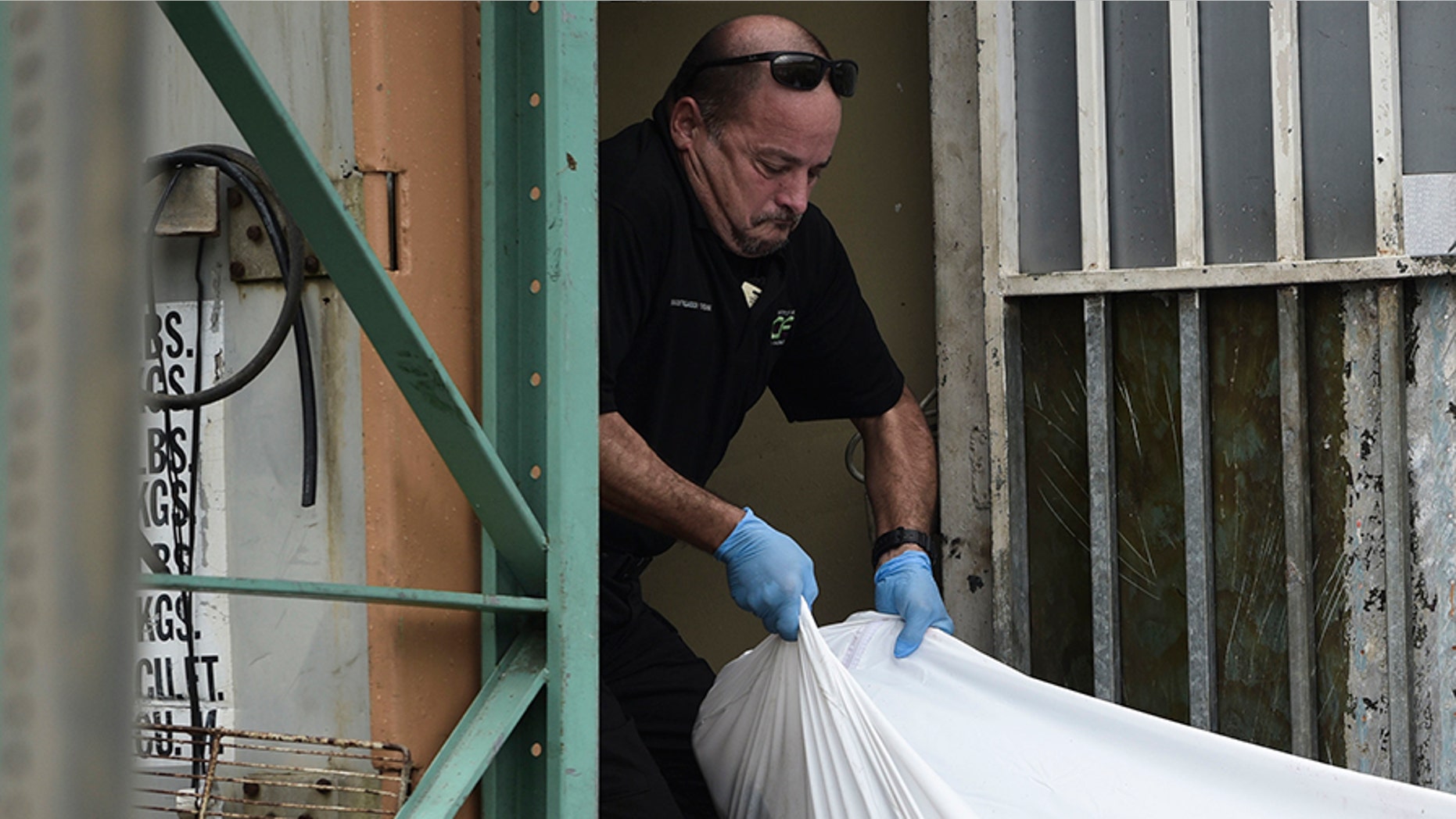 Forensic worker moves a body at a San Juan crime scene in January, Puerto Rico's deadliest month in recent years