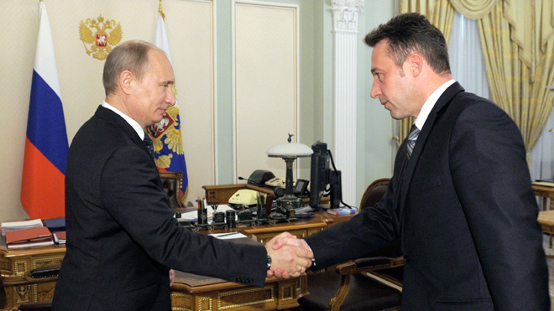 May 18, 2012: Russian President Vladimir Putin shakes hands with Igor Kholmanskikh, right, a section head at the Uralvagonzavod tank factory in the Urals city of Nizhny Tagil that builds battle tanks, in Novo-Ogaryovo residence outside Moscow.