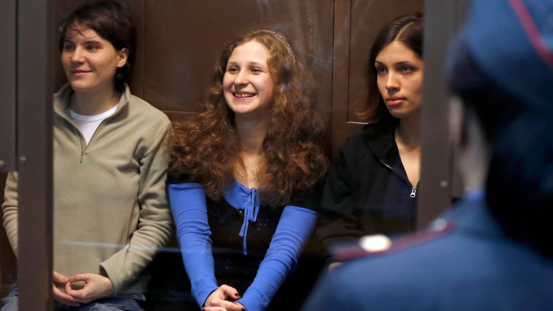 Oct. 10, 2012: Feminist punk group Pussy Riot members, from left, Maria Alekhina, Yekaterina Samutsevich and Nadezhda Tolokonnikova sit in a glass cage at a court room in Moscow.