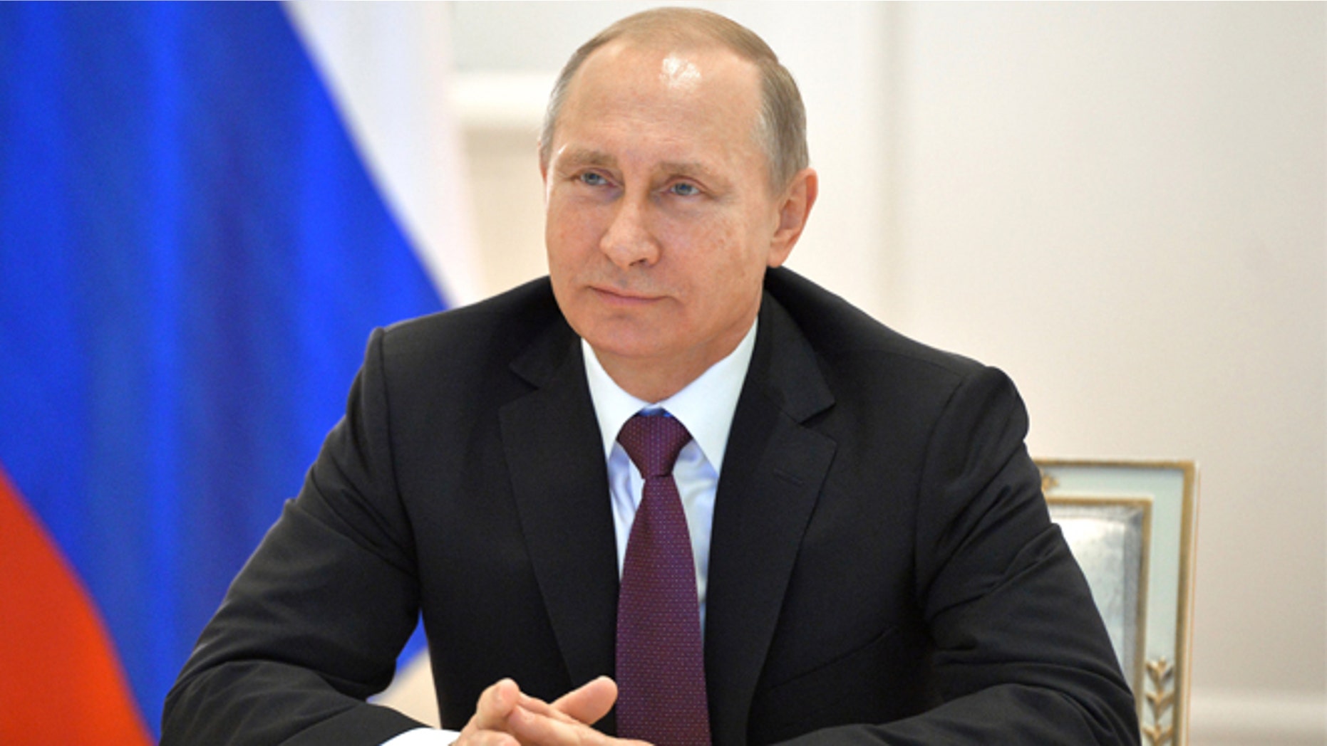Russian President Vladimir Putin smiles during a live video link with members of Russian Geographical Society expedition to the Southern Pole in Moscow's Kremlin, Russia on Friday, Dec. 26, 2014.