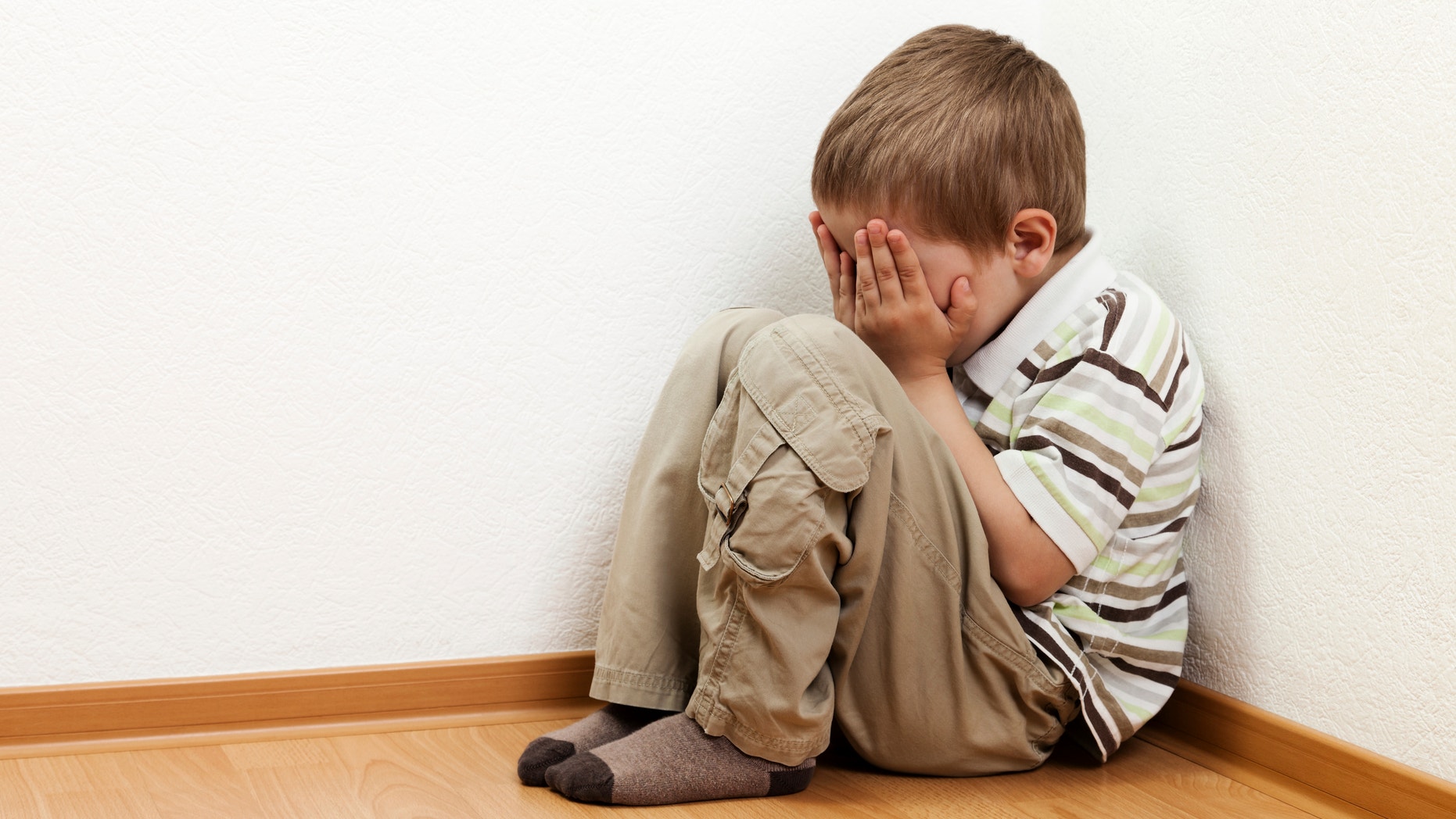 Little child boy wall corner punishment sitting