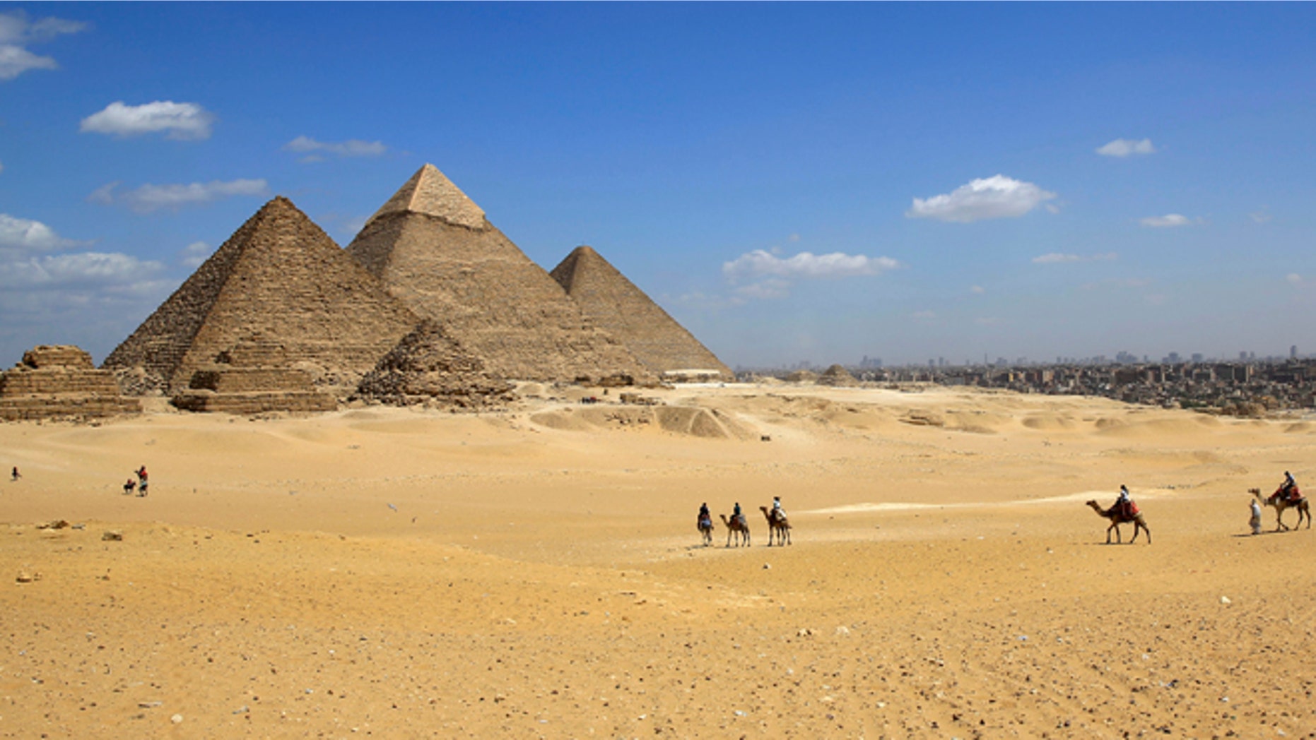 April 9, 2015: Tourists ride camels at the historical site of the Giza Pyramids in Giza, near Cairo, Egypt. (AP)