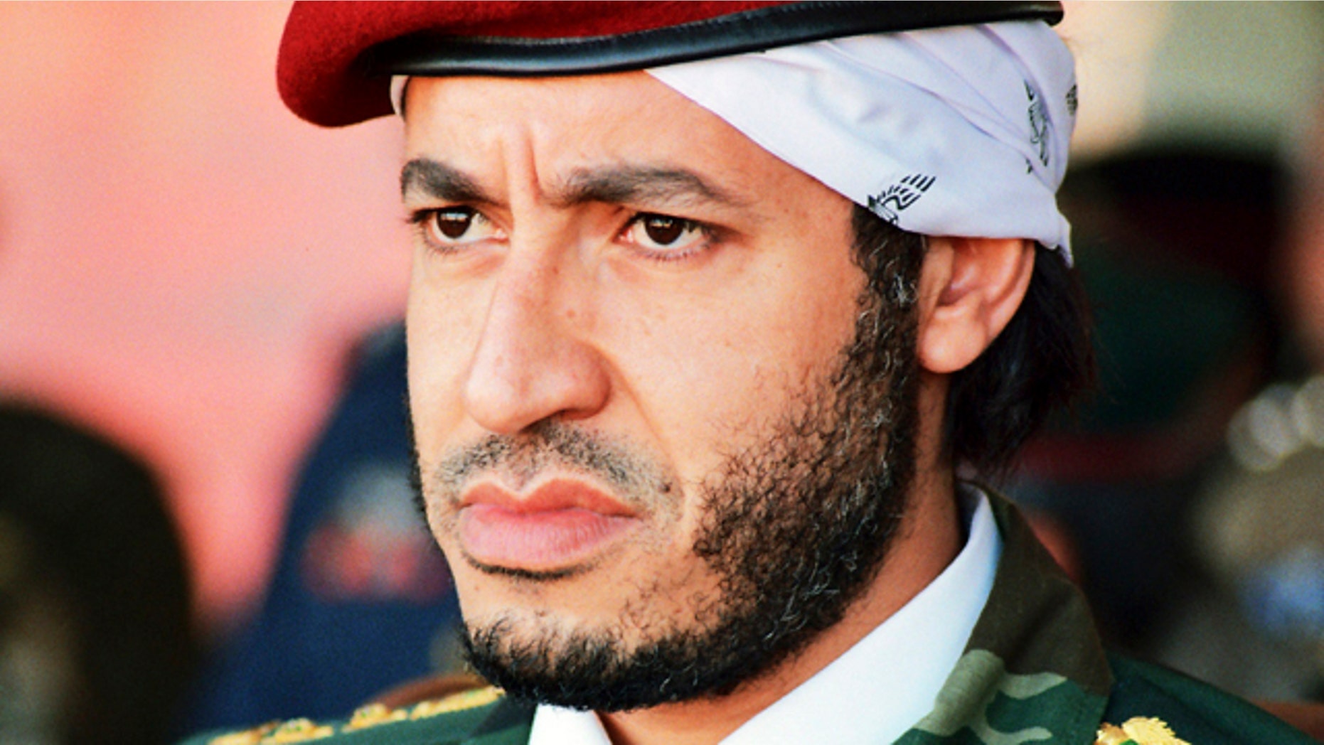 FILE - In this undated photo made available Sunday, Sept. 25, 2011, al-Saadi Gadhafi, son of Libyan leader Muammar Qaddafi, watches a military exercise by the elite military unit commanded by his brother, Khamis, in Zlitan - 90 miles southeast of Tripoli, Libya. Muammar Qaddafi's son, al-Saadi, has denied allegations of corruption and intimidation and says an Interpol decision to put him on the equivalent of its most-wanted list is political.
