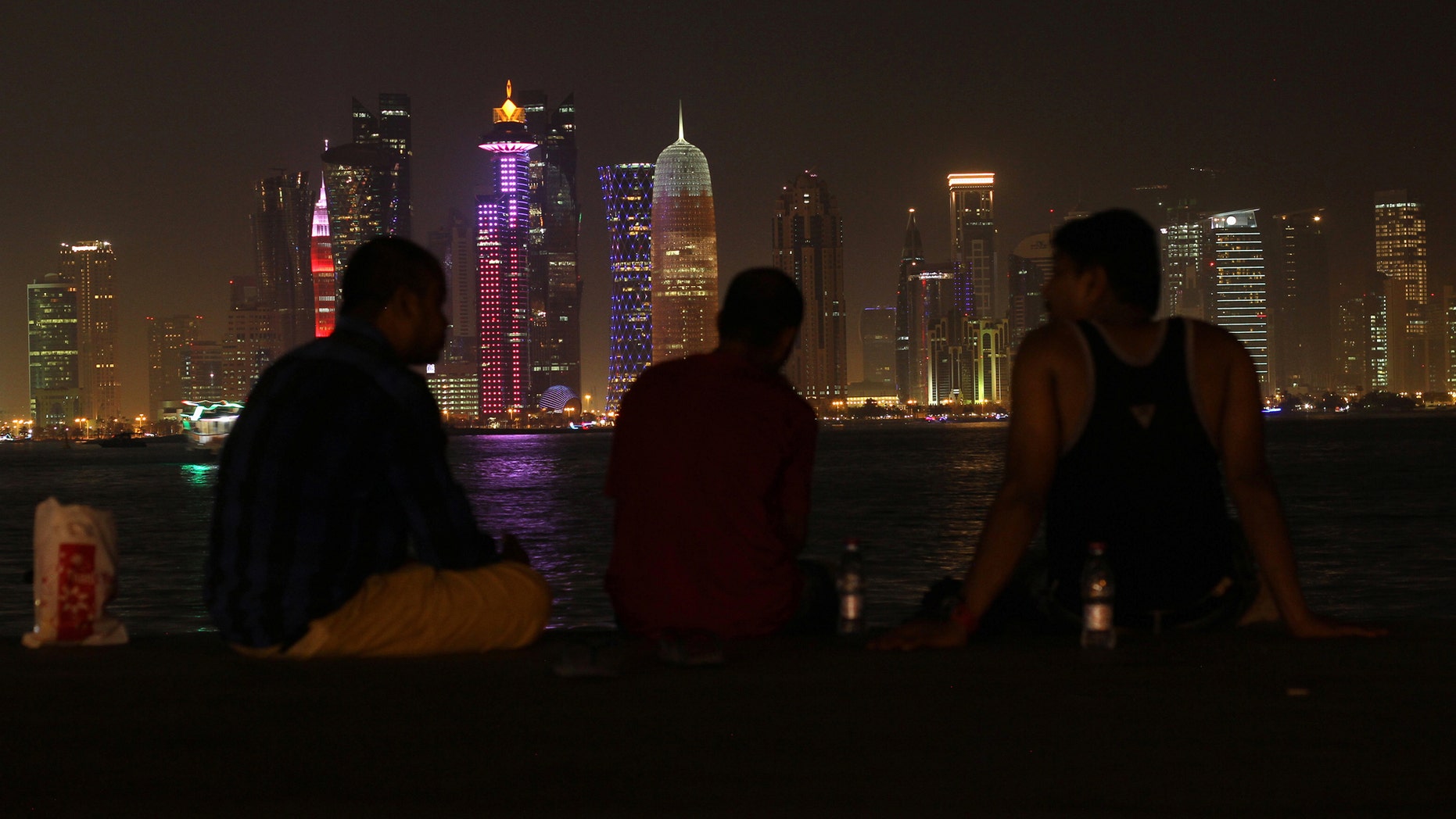 People sit on the corniche in Doha, Qatar, June 15, 2017.