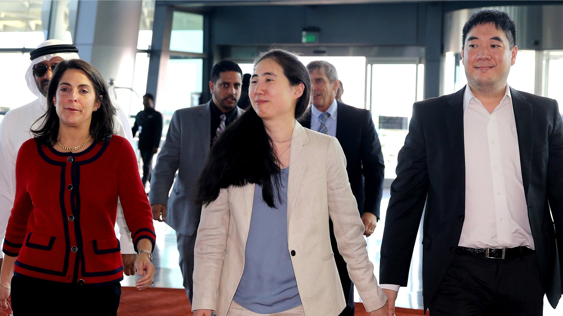 Dec. 3, 2014: American couple Grace, center, and Matthew Huang, right, walk to their departure gate with U.S. Ambassador to Qatar, Dana Shell Smith, left, at the Hamad International Airport in Doha, Qatar