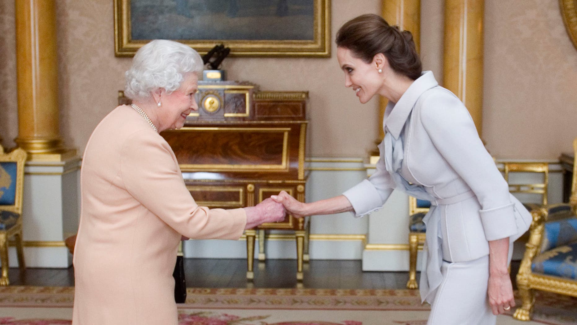 October 10, 2014. Angelina Jolie, right, is presented with the Insignia of an Honorary Dame Grand Cross of the Most Distinguished Order of St Michael and St George by Queen Elizabeth II at Buckingham Palace, London.