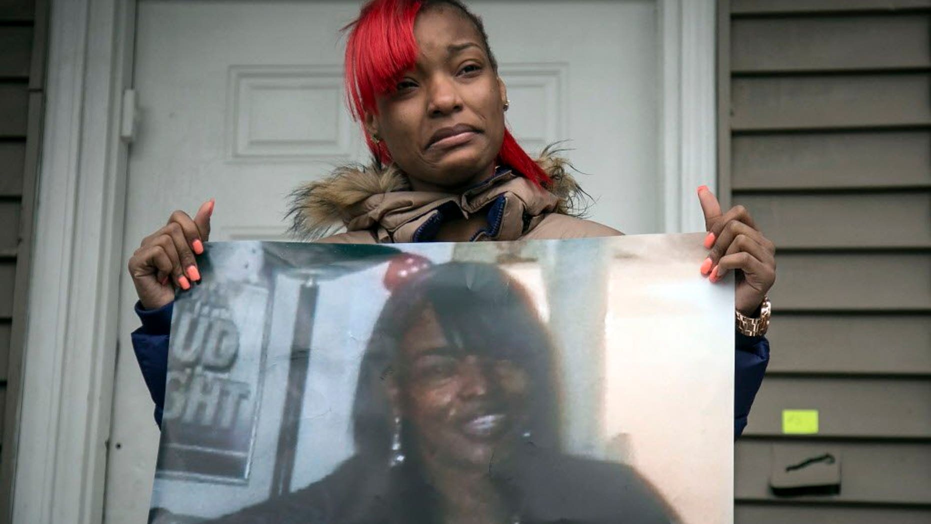 Latonya Jones holds a photo of her mother, Bettie, during a vigil in December. Bettie Jones and Quintonio LeGrier, were killed by Chicago police in December.