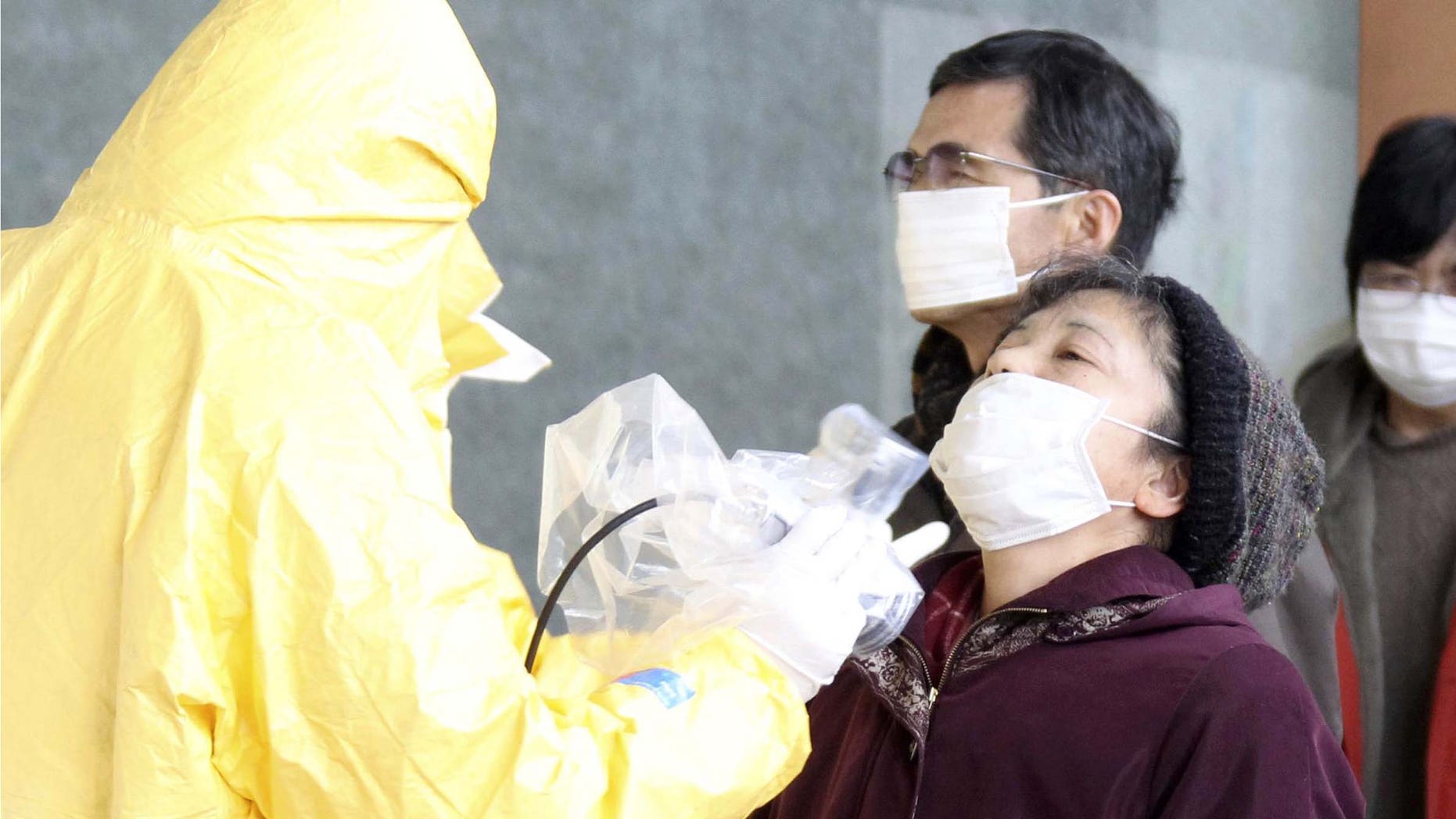 A woman is tested for radiation exposure in Nihonmatsu, northern Japan Wednesday, March 16, 2011 after Friday's massive earthquake and tsunami. (AP Photo/Yomiuri Shimbun, Koichi Nakamura) JAPAN OUT, MANDATORY CREDIT