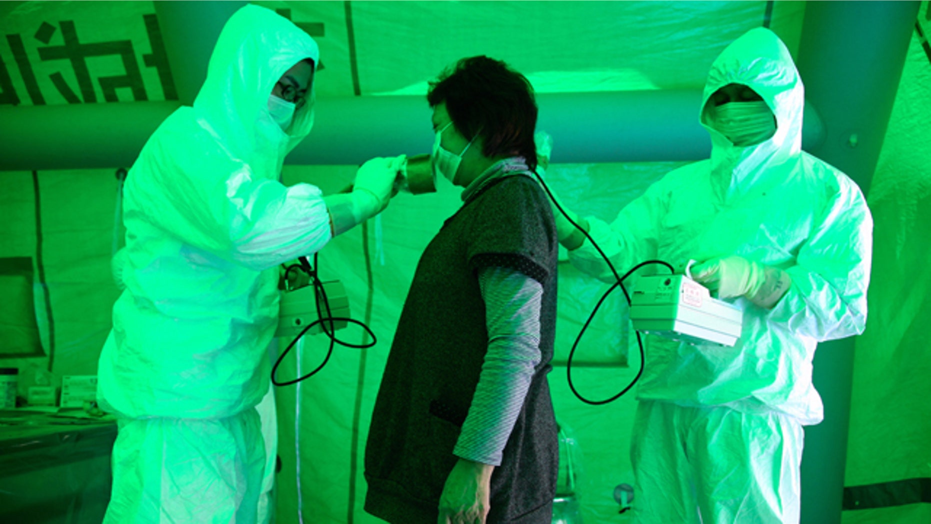 Medical staff use a Geiger counter to screen a woman for possible radiation exposure at a public welfare centre in Hitachi City, Ibaraki, March 16, 2011, after she evacuated from an area within 20km (12.4 miles) radius of the Fukushima Daiichi nuclear plant. The woman was tested negative for radiation exposure. Radiation has been released into the atmosphere at the Fukushima Daiichi nuclear plant run by Tokyo Electric Power Co. on the country's northeast coast, which was badly damaged after a massive earthquake and tsunami on March 11.