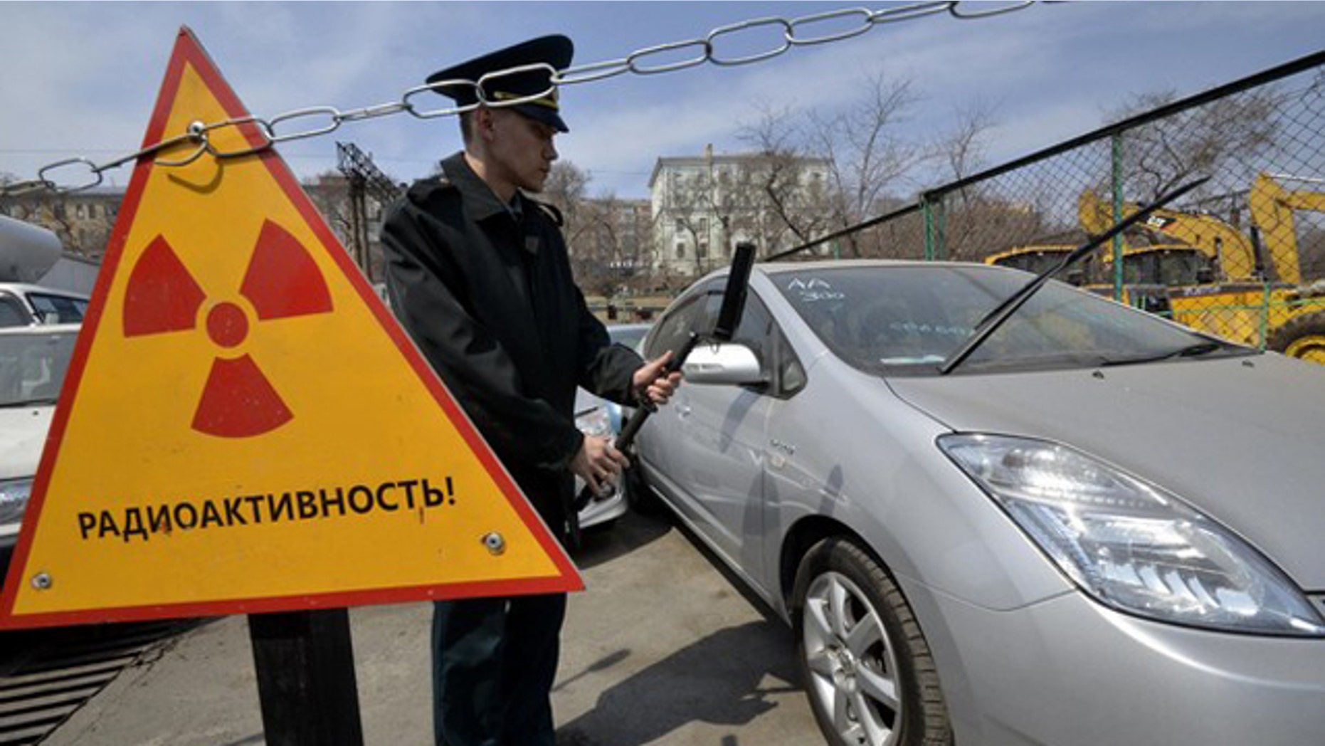 A customs officer measures the radiation level of an automobile delivered from Japan, in Russia's far eastern city of Vladivostok April 14, 2011. About 300 cars and other vehicles are delivered from neighbouring Japan to the port. Radioactive background has been revealed in 49 vehicles lately. These machines will be kept in the port until the Russian Federal Service on Customers' Rights makes a decision on their fate, Russian customs officers said. The sign reads "Radioactivity".