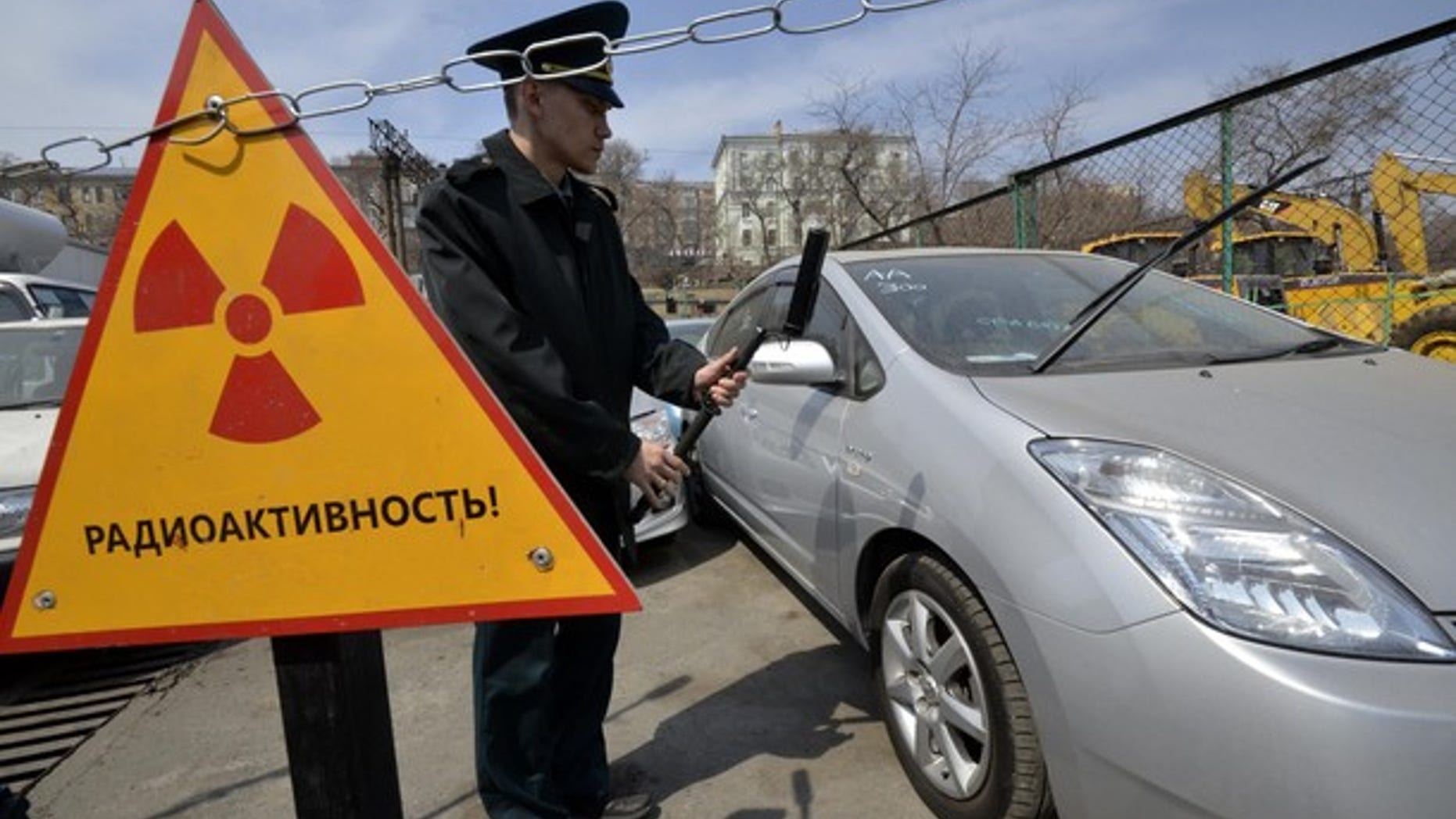 A customs officer measures the radiation level of an automobile delivered from Japan, in Russia's far eastern city of Vladivostok April 14, 2011.