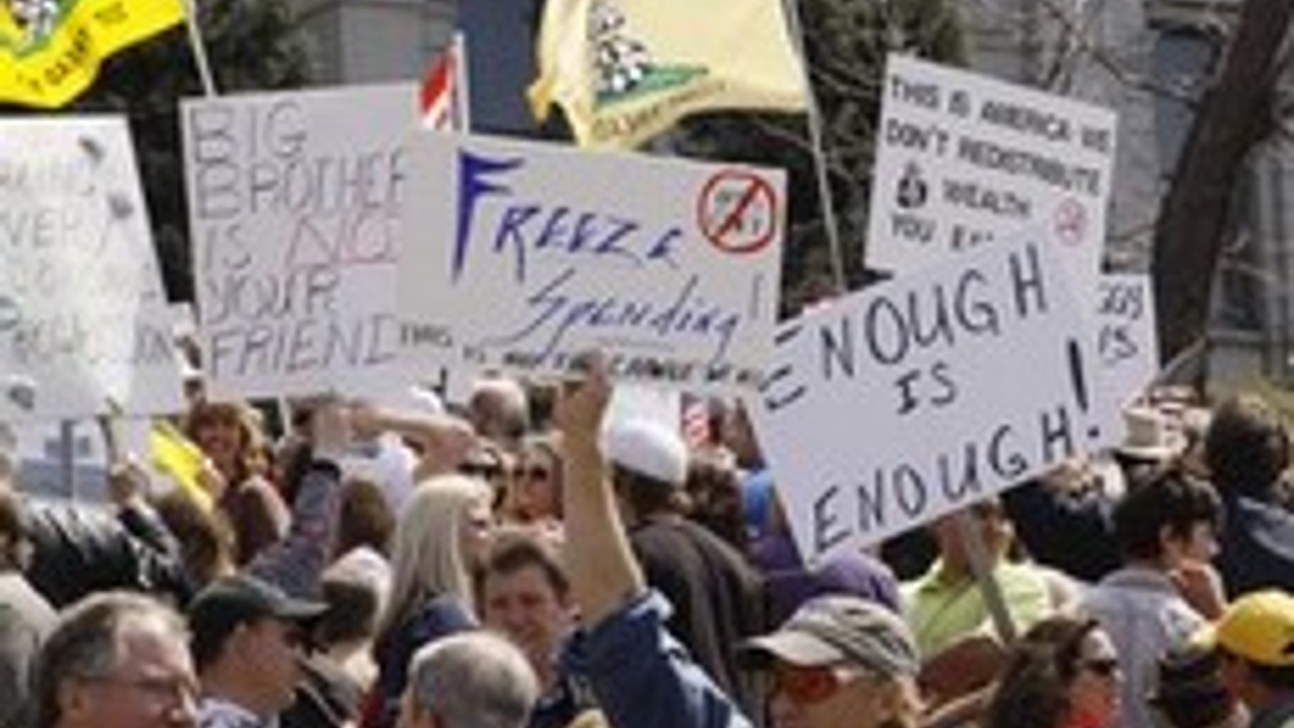 People wave signs at a "tea party" protest on the grounds of the Colorado tate capitol in Denver April 15, 2009. Protests were held in many U.S. cities loosely inspired by the 1773 Boston Tea Party rebellion against British colonial taxes, which helped spark the American revolution. The crowds demonstrated against taxes, government bailouts and U.S. President Barack Obama's budget proposal. REUTERS/Rick Wilking (UNITED STATES POLITICS CONFLICT BUSINESS)