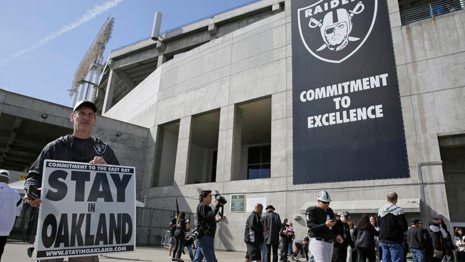 March 25, 2017: John P. Kelleher holds up a sign outside the Oakland Coliseum before the start of a rally to keep the Oakland Raiders from moving.