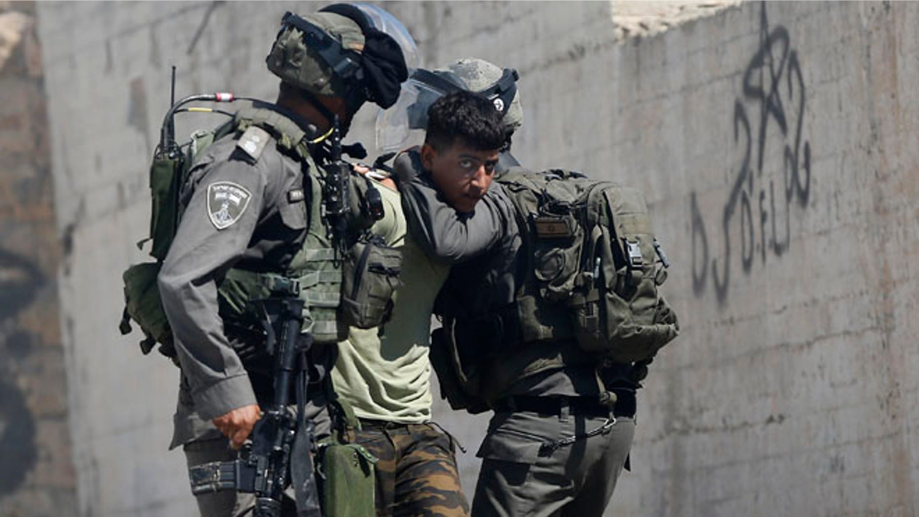 Israeli border police arrest a Palestinian during clashes in the West Bank village of Deir Abu Mash'al near Ramallah, Saturday.