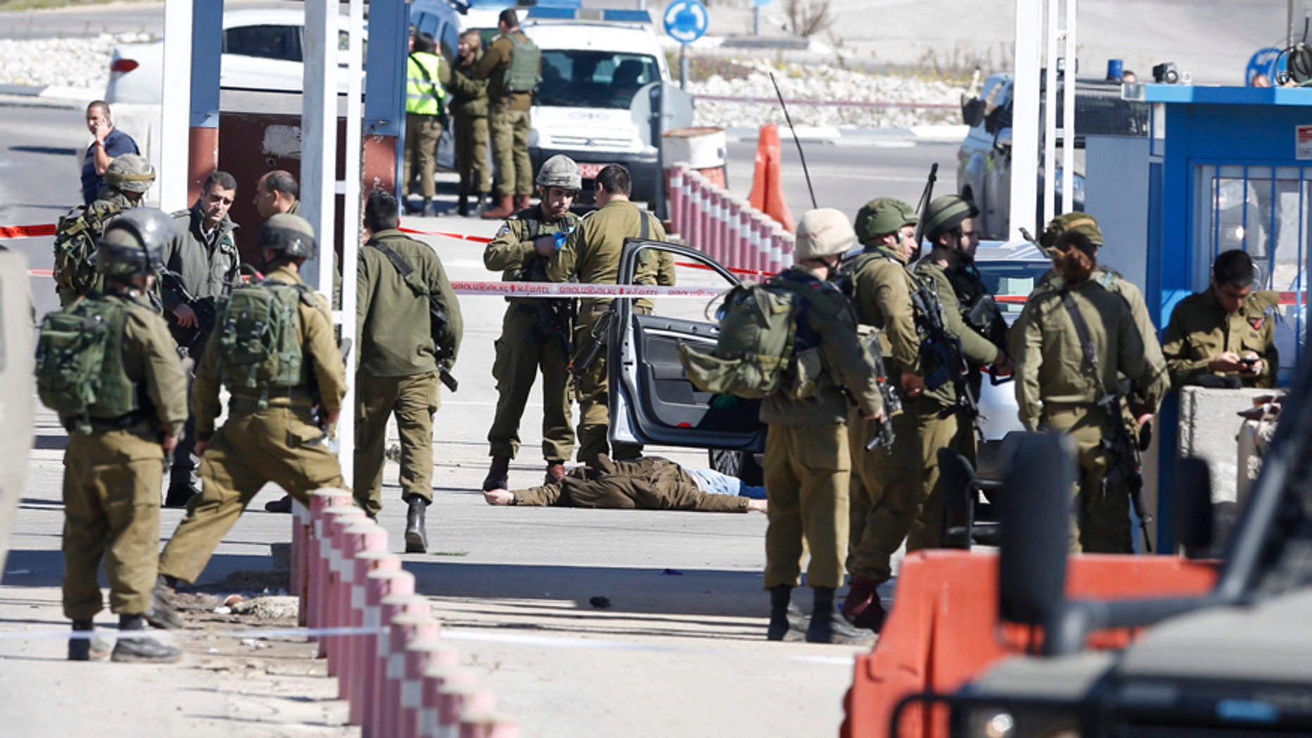 Jan. 31, 2016: Israeli security forces inspect the body of a Palestinian identified as Amjad Sukkari, inside a car, at the checkpoint between the city of Ramallah and Jewish settlement of Beit El in the West Bank.