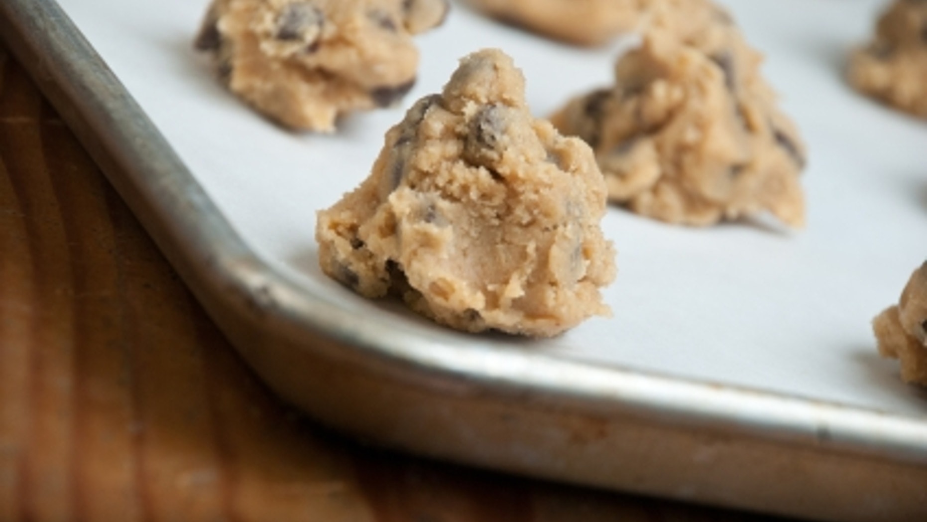 A pan of freshly prepared homemade chocolate chip cookie dough sits on the counter waiting to go into the oven.