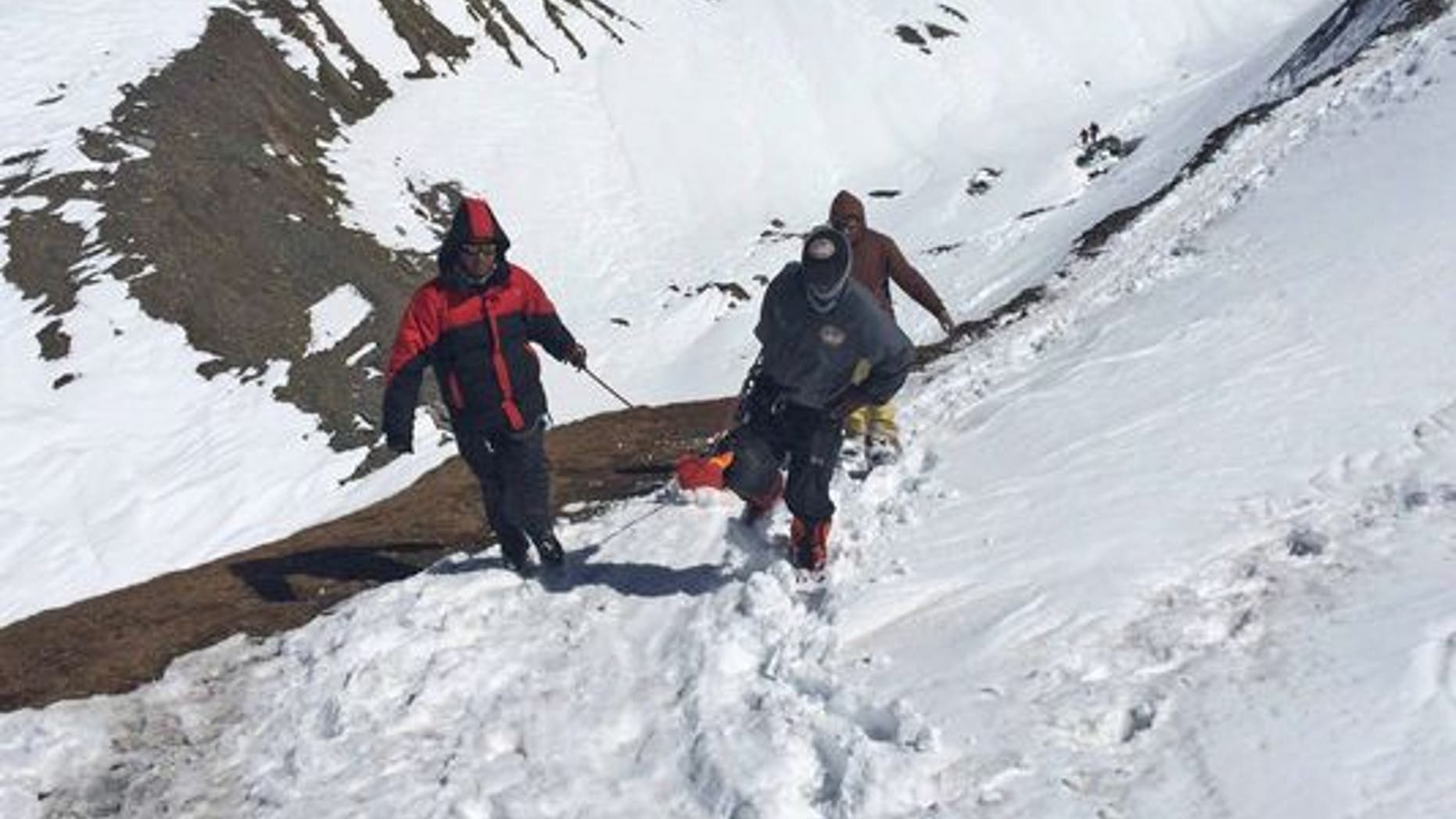 Rescue team members carry the body of an avalanche victim at Thorong La pass area in Nepal, on Oct. 17, 2014.