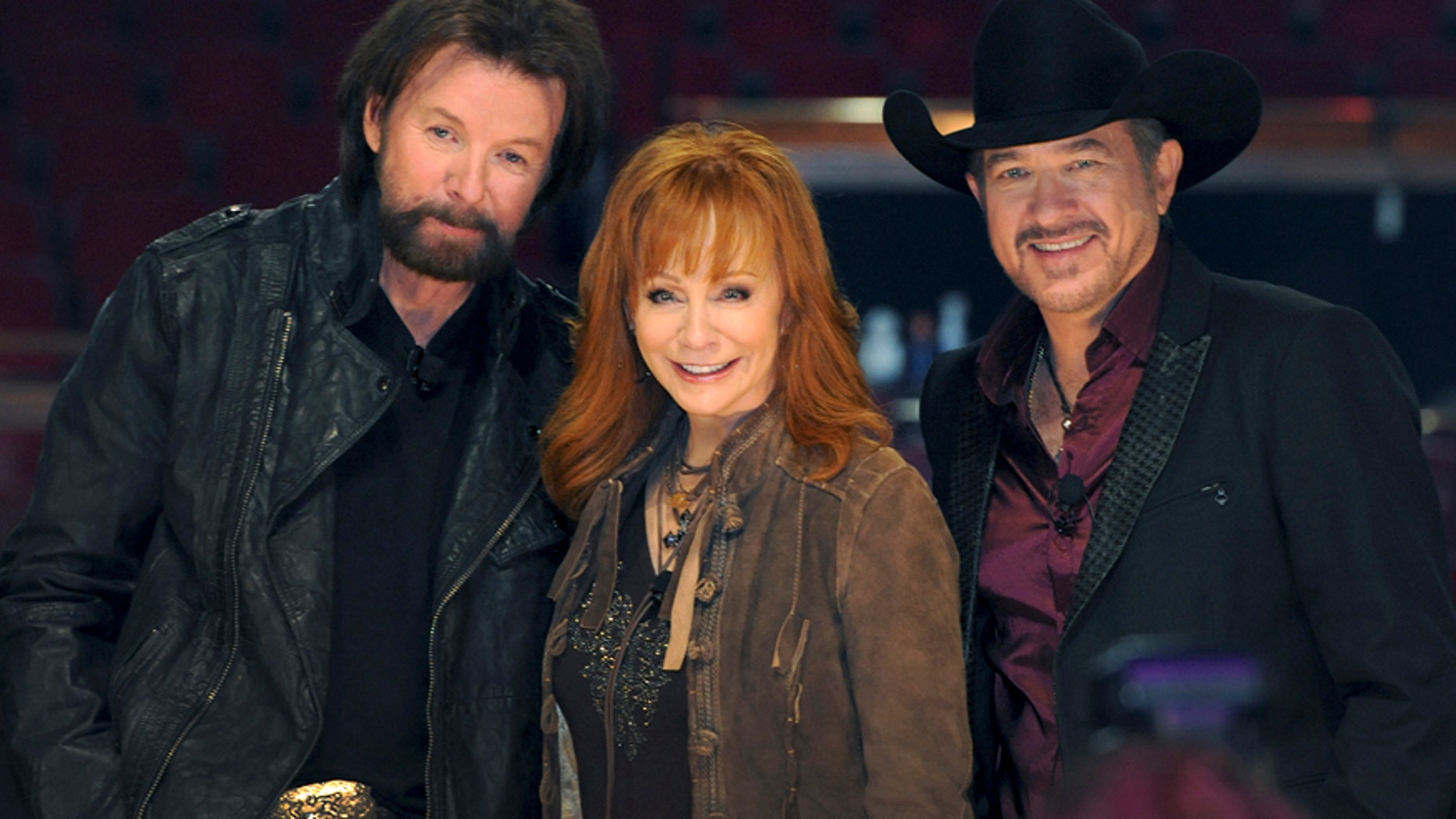 In this photo provided by the Las Vegas News Bureau, country music stars Reba McEntire, center, poses with Ronnie Dunn, left, and Kix Brooks, of the duo Brooks & Dunn, Wednesday, Dec. 3, 2014, in the Colosseum at Caesars Palace in Las Vegas.