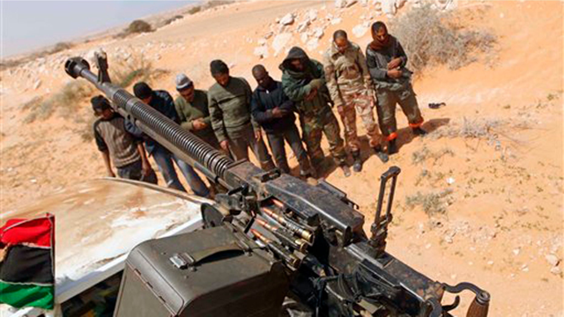 Libyan rebels pray 75 miles east of Sirte in eastern Libya March 28.