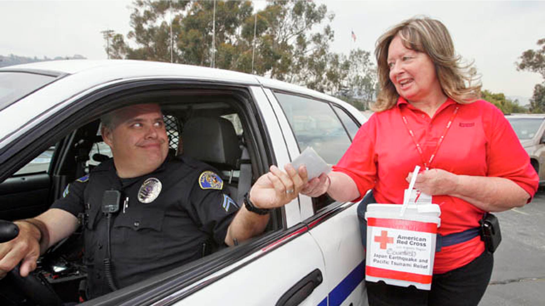 March 14: Alhambra Police officer Kevin Lang drives in to drop checks and cash donated by his station police officers to American Red Cross volunteer Cathy Sproule for the Japan Earthquake and Pacific Tsunami Relief Fund at the Rose Bowl in Pasadena, Calif. (AP)