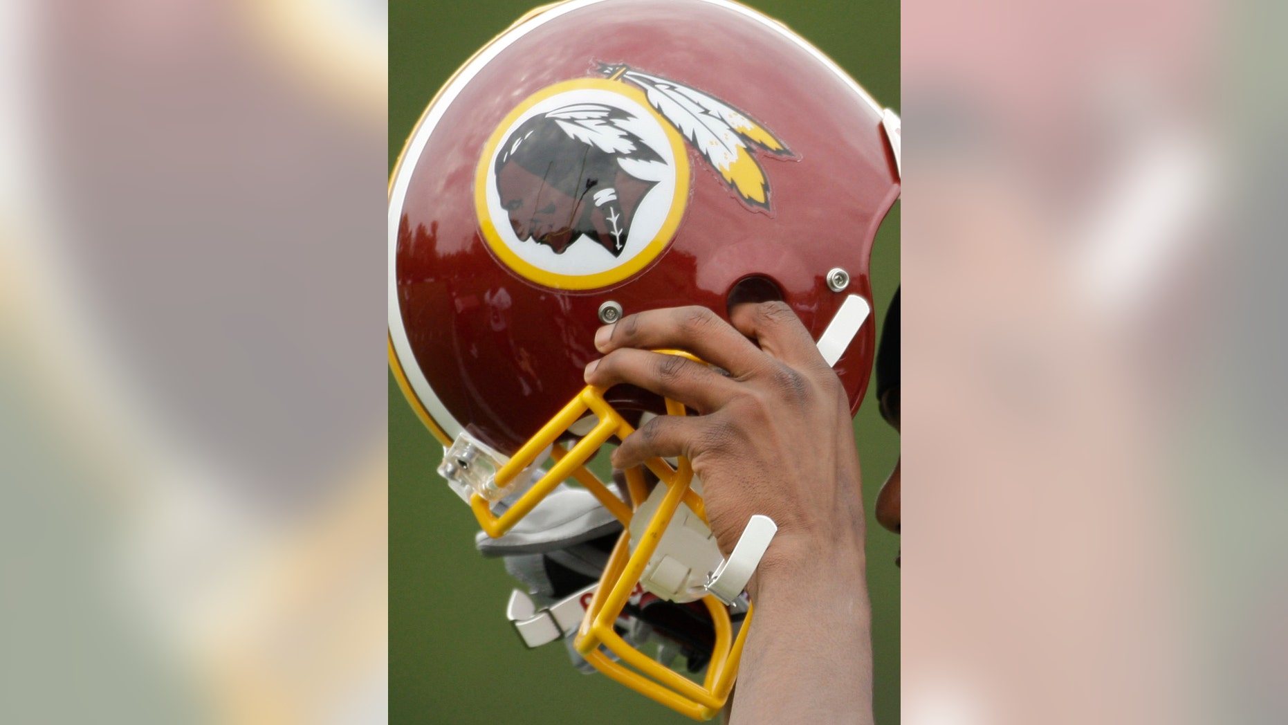 In this file photo, Washington Redskins Marko Mitchell puts his helmet on during their NFL football minicamp practice at their training facility in Ashburn, Va.